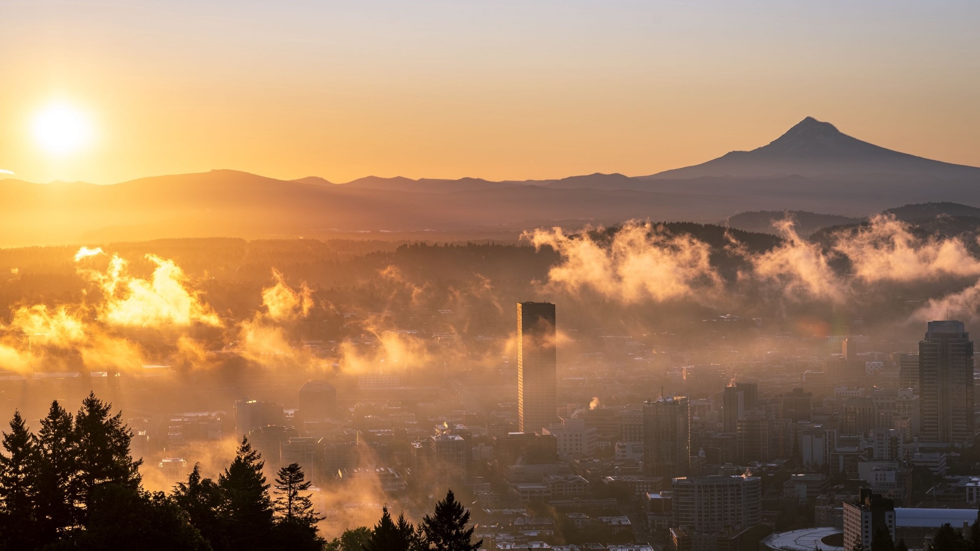 Cityscape at sunrise with mountains and fog HD Wallpaper