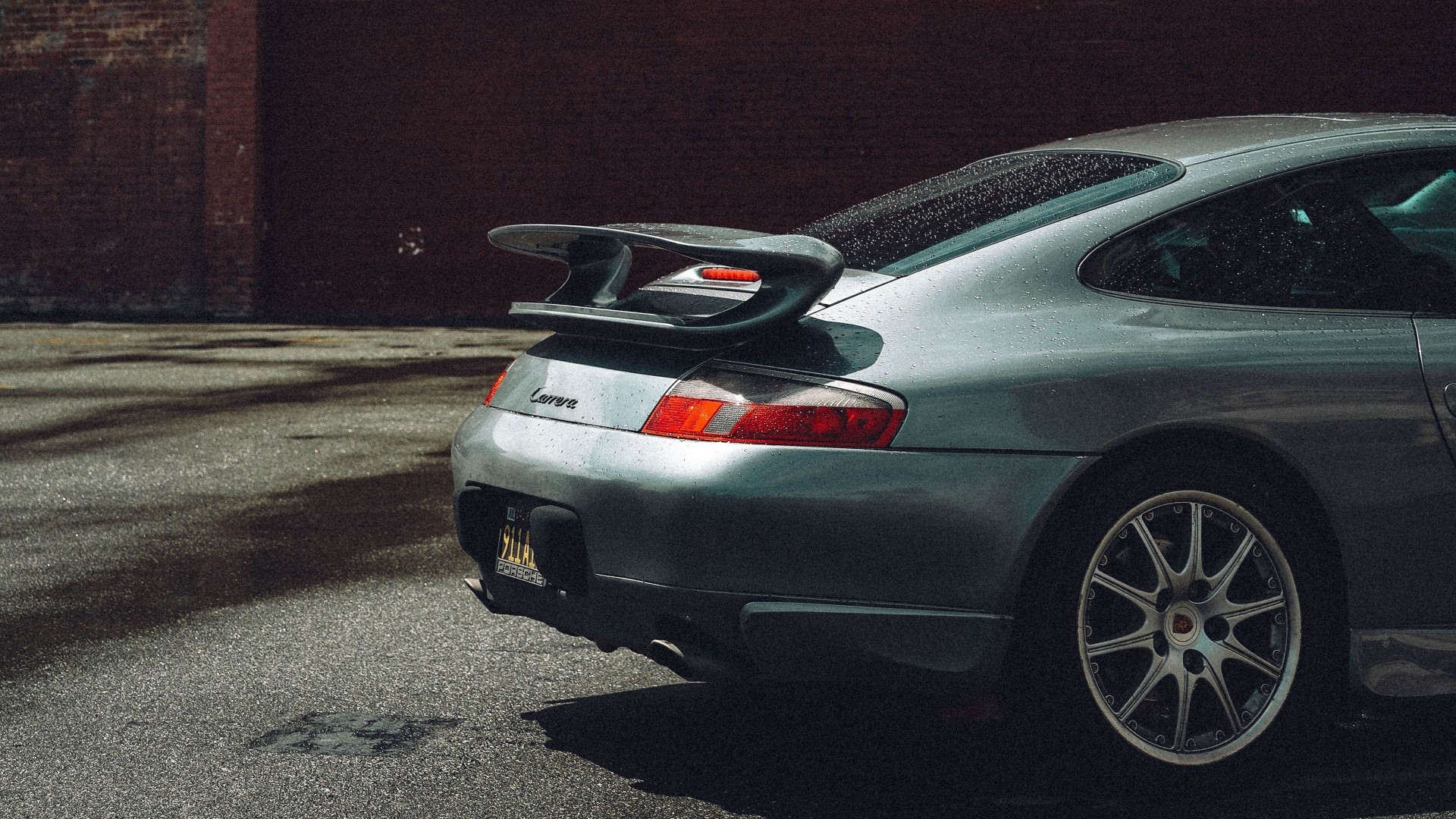Porsche Carrera parked near brick wall HD Wallpaper