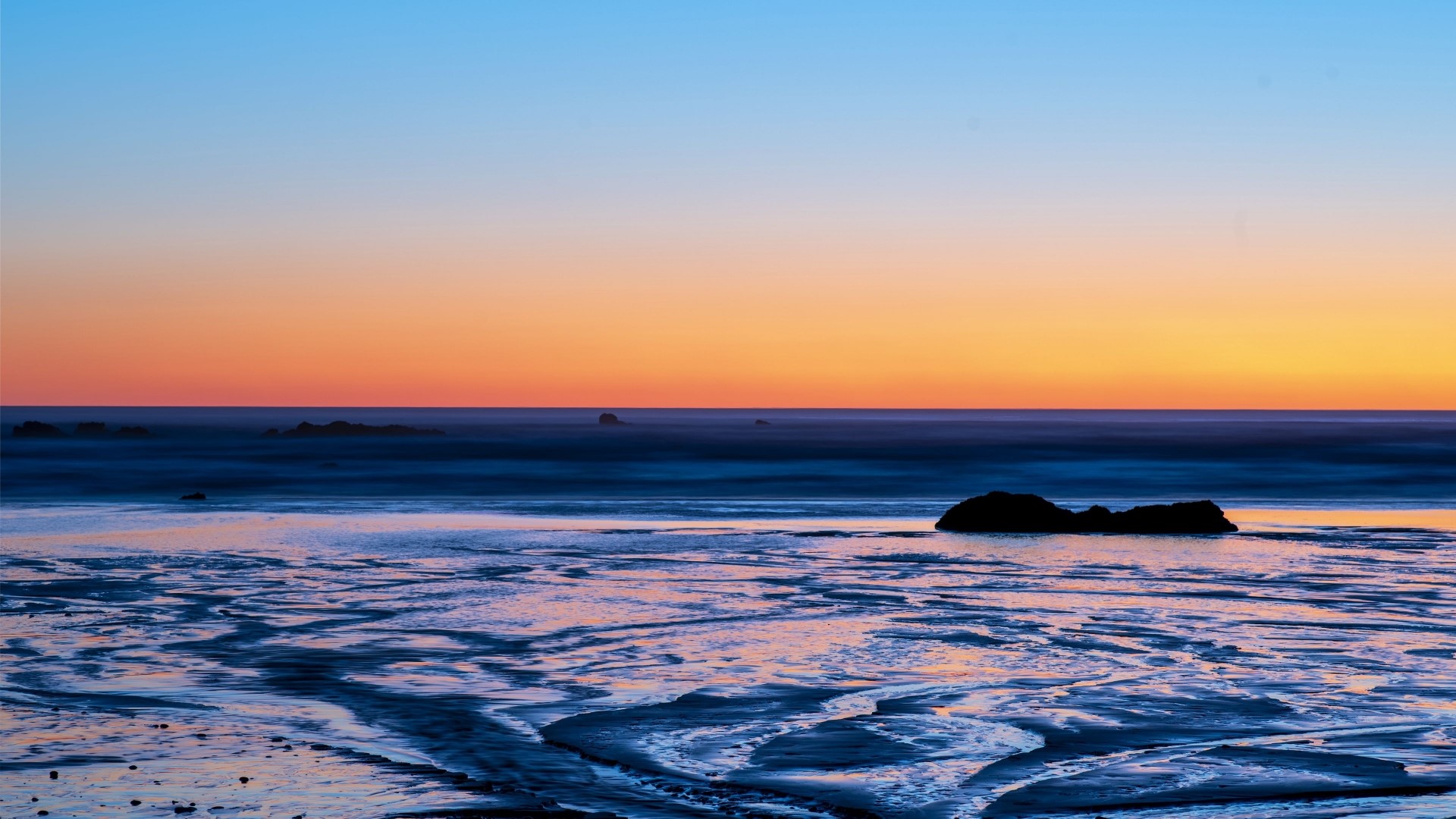 Sunset over the ocean with rocks HD Wallpaper