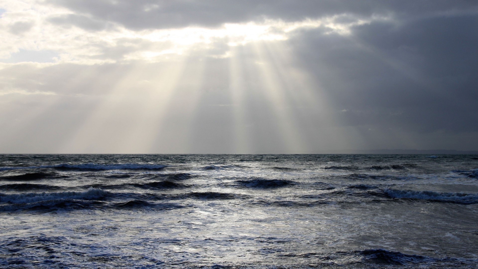 Sunbeams through clouds over ocean waves HD Wallpaper