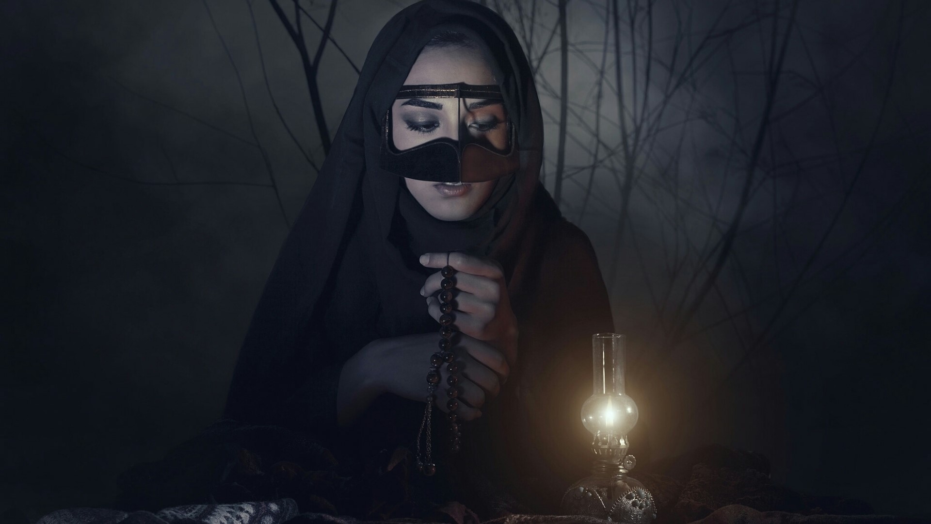 Woman in hijab praying with prayer beads HD Wallpaper