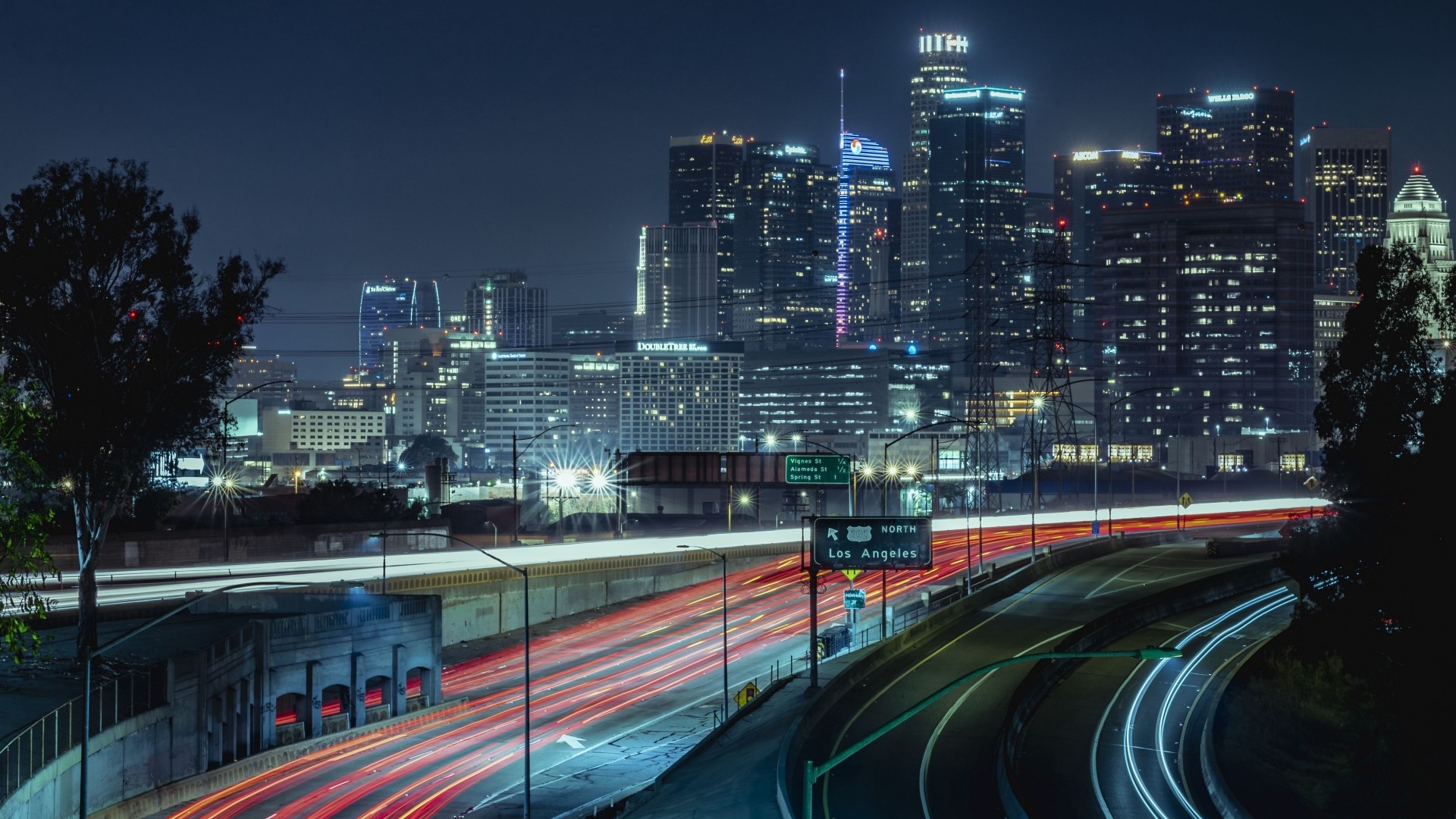 Nighttime Los Angeles cityscape with light trails on highway HD Wallpaper