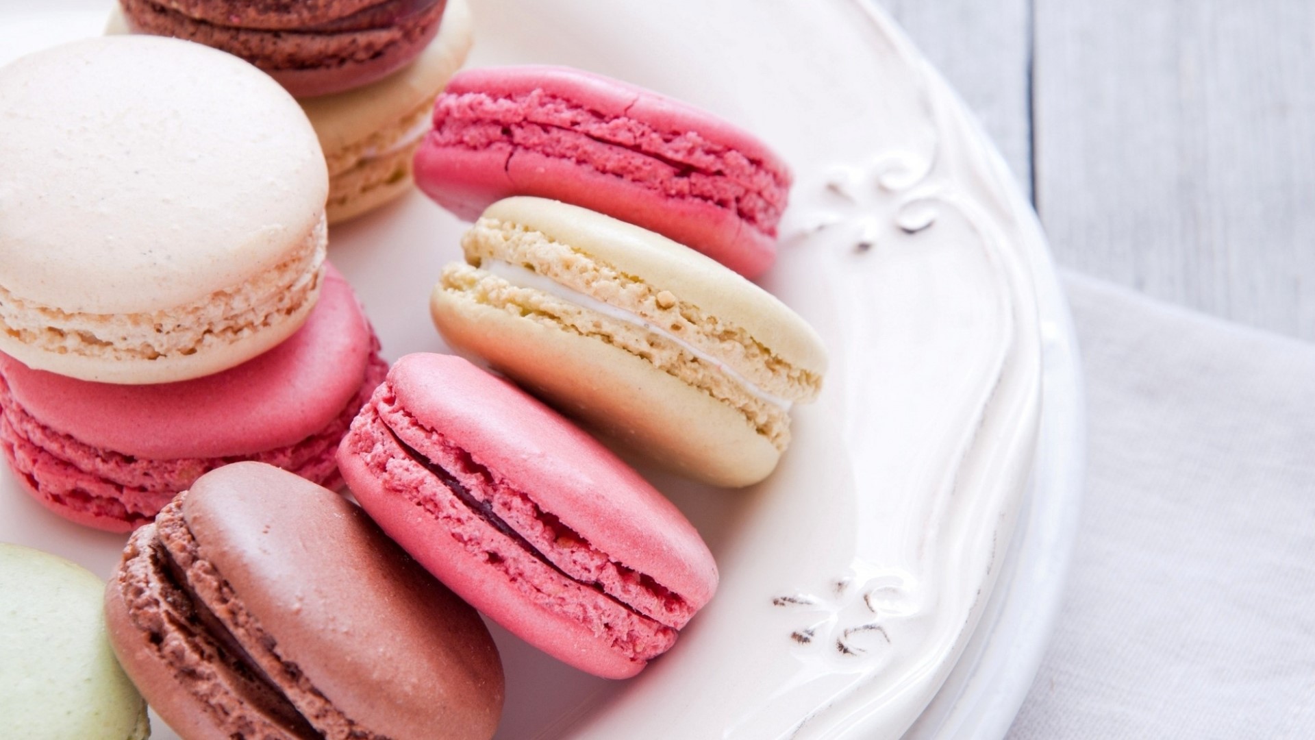 Assortment of colorful macarons on a white plate HD Wallpaper