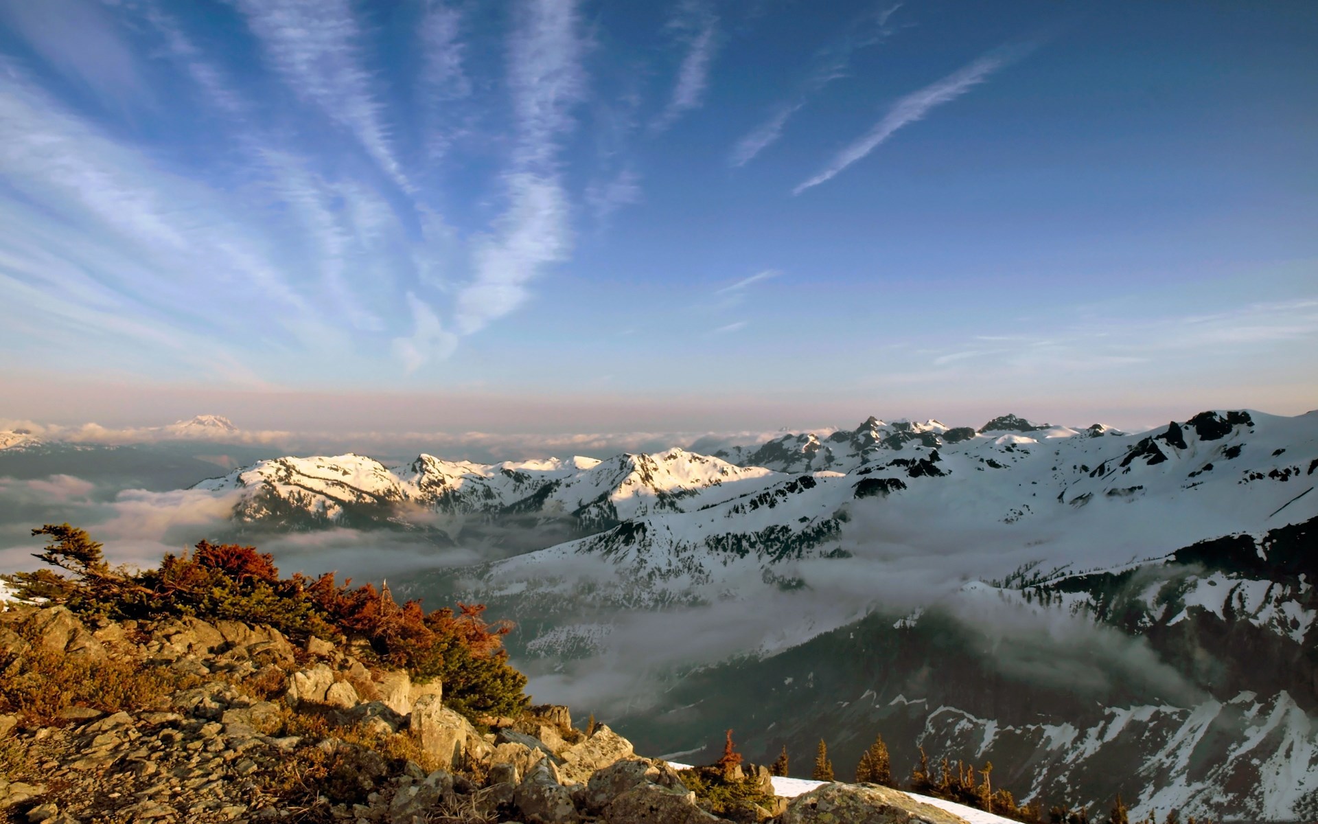 Snow-capped mountains under a cloudy sky HD Wallpaper