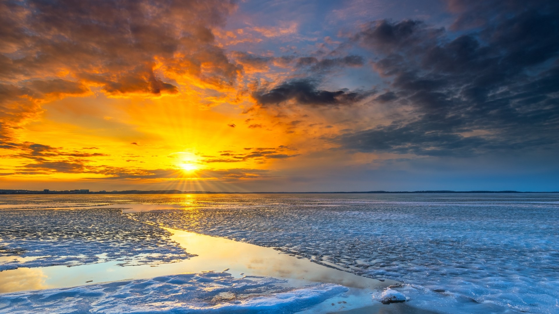 Sunset over a frozen lake with dramatic clouds HD Wallpaper