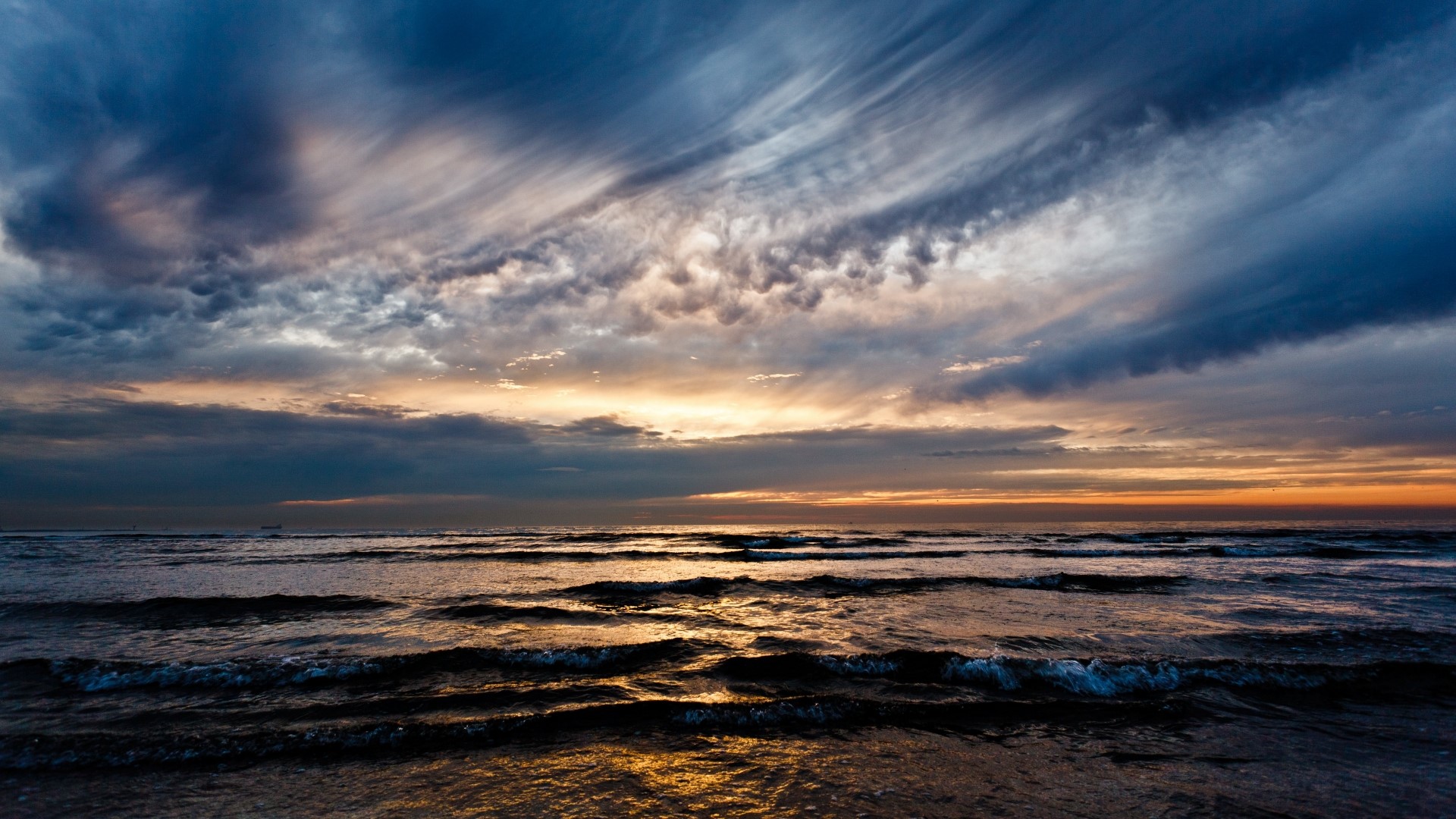 Waves crashing on a beach at sunset HD Wallpaper