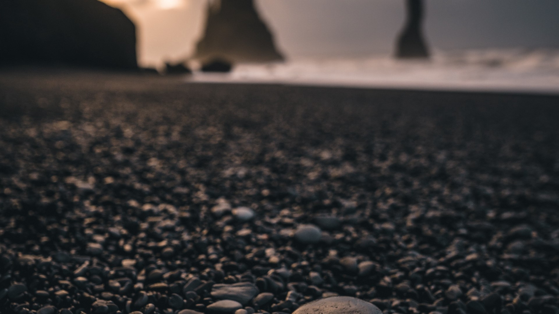 Pebble beach with rock formations and ocean waves HD Wallpaper