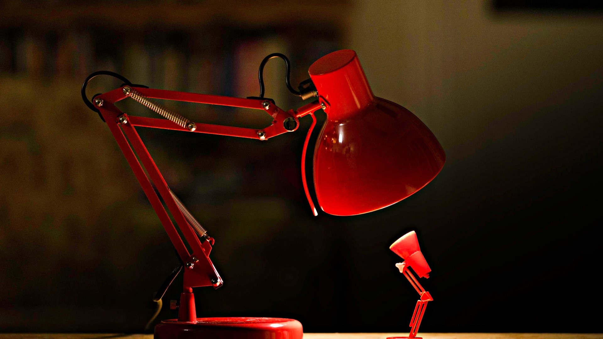Two red desk lamps, one large and one small HD Wallpaper