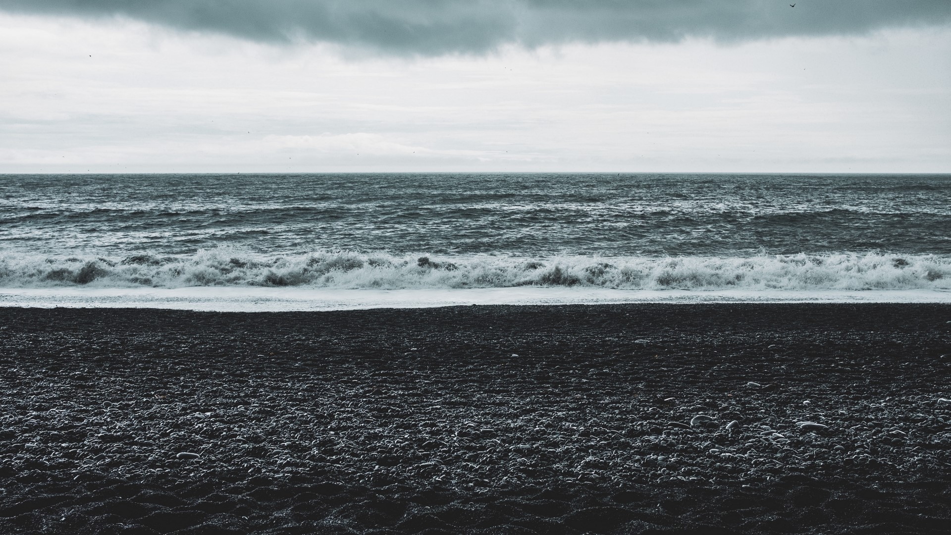 Black sand beach with waves and cloudy sky HD Wallpaper