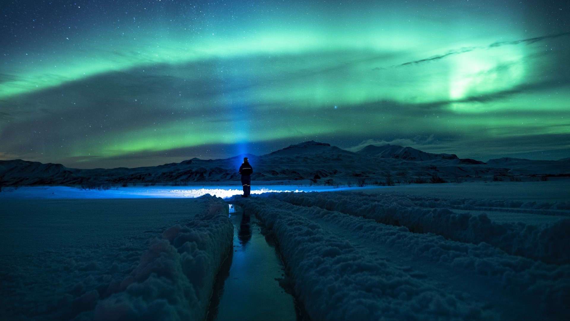 Person with flashlight under Northern Lights HD Wallpaper