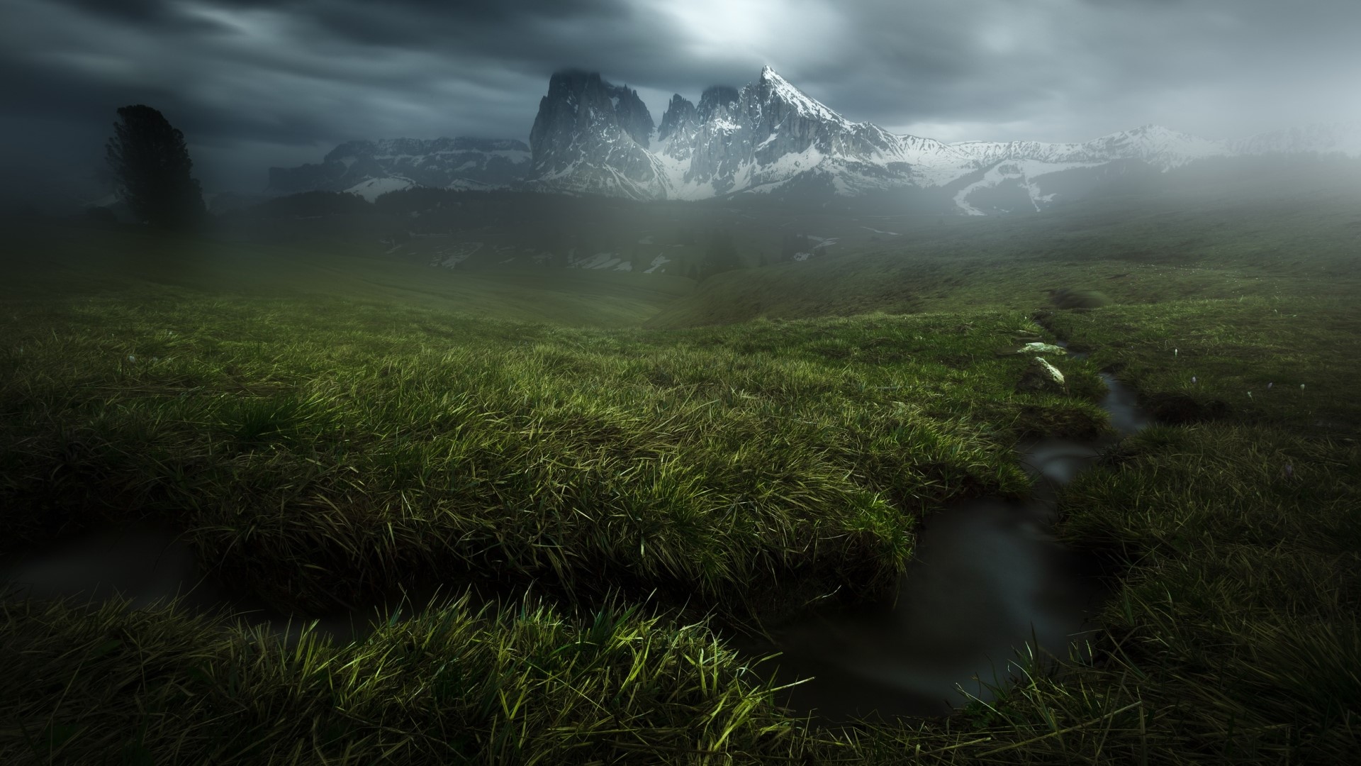 Misty mountains and green meadow with stream HD Wallpaper