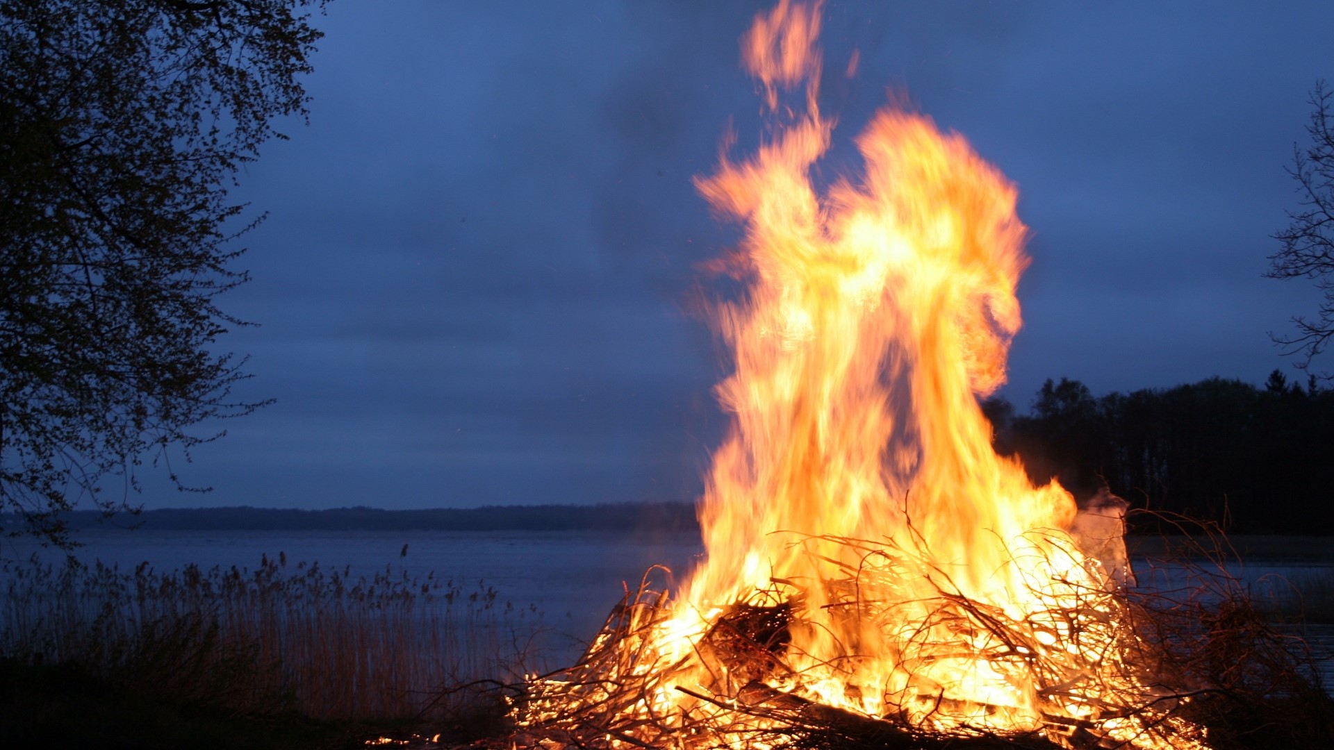 Bonfire on a lake at dusk HD Wallpaper