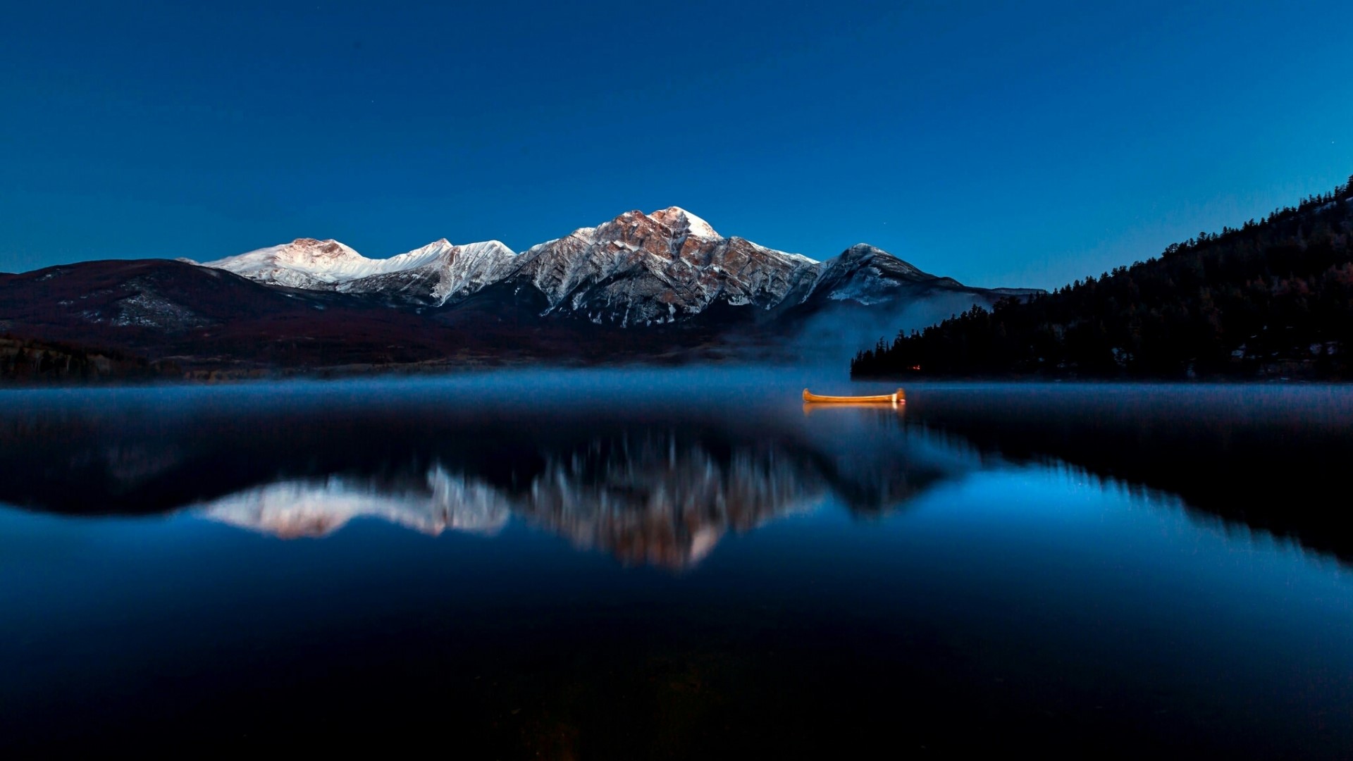 Canoe on a misty lake with snow-capped mountains HD Wallpaper