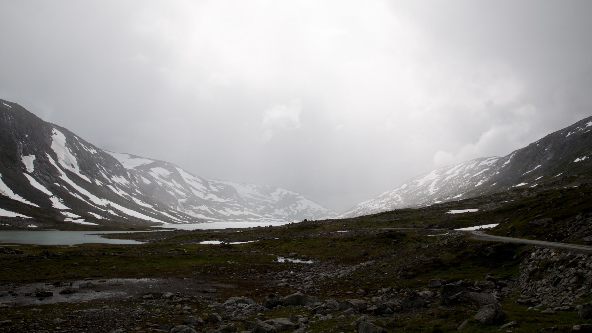 Misty mountain valley with snow and a lake HD Wallpaper