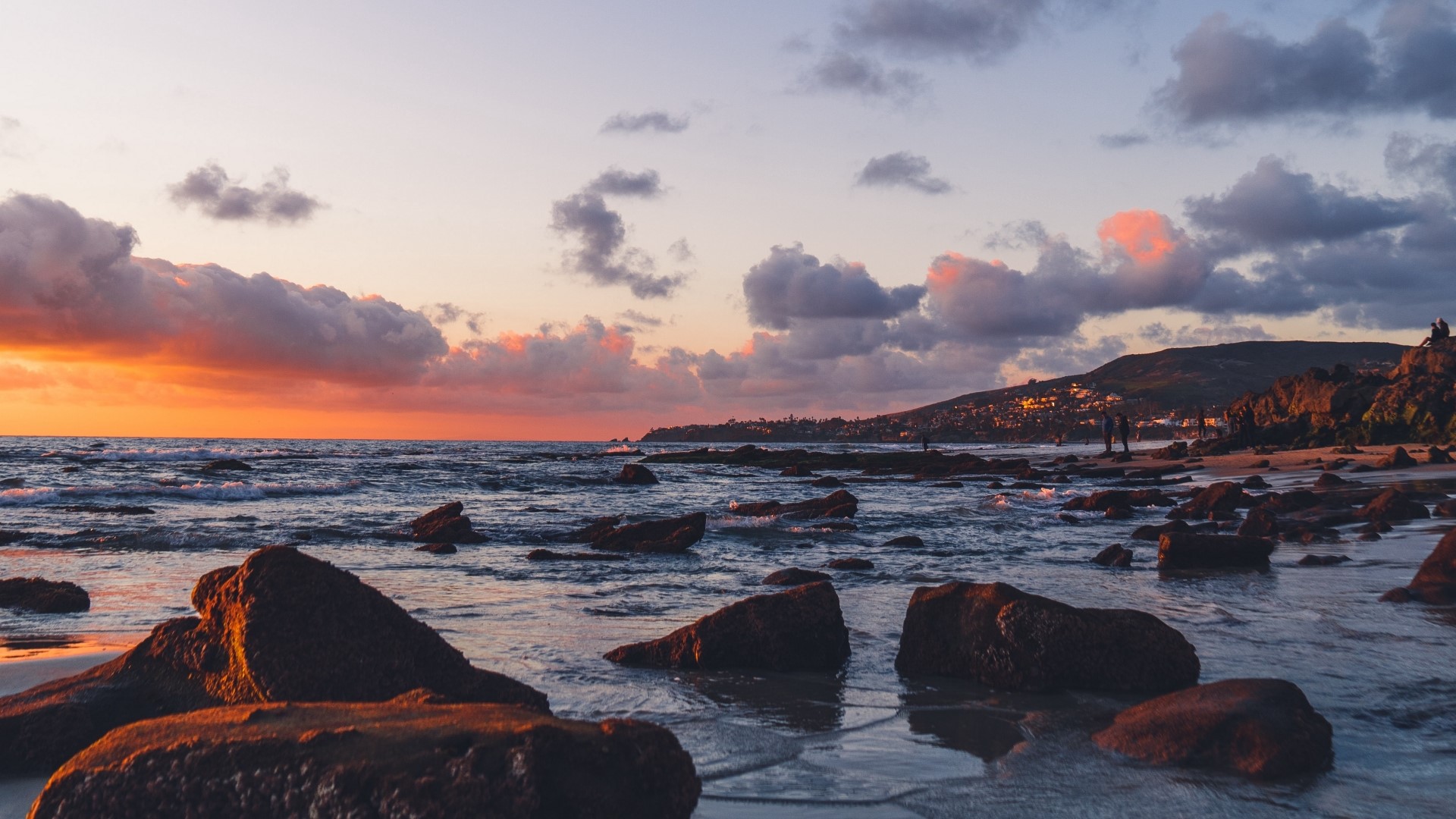 Sunset over a rocky coast with ocean waves HD Wallpaper