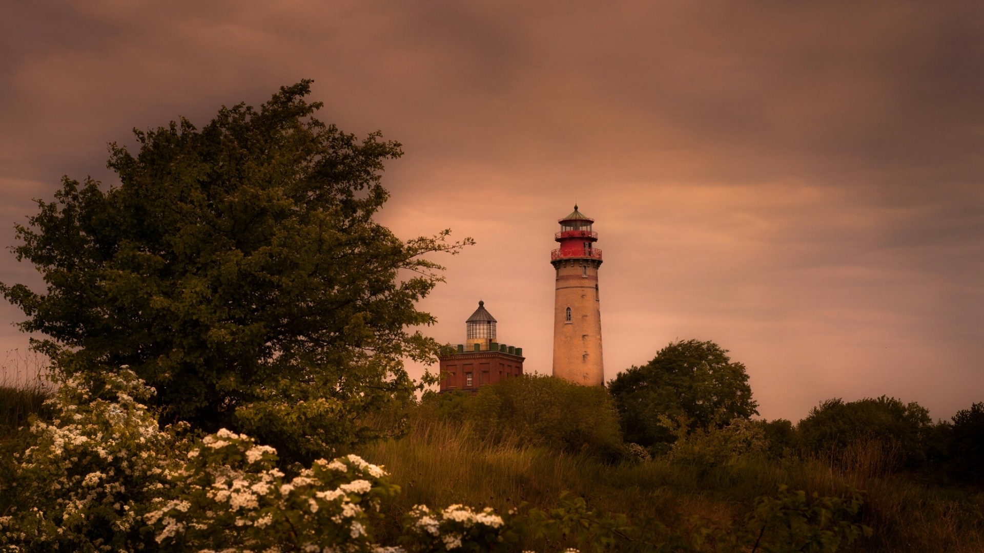 Two lighthouses on a hill with trees HD Wallpaper