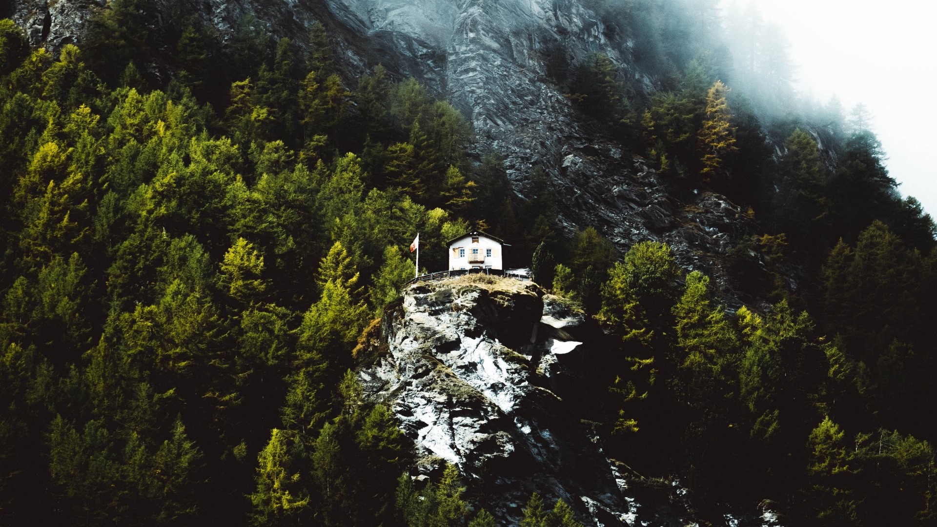 Small white house on a rocky cliff surrounded by trees HD Wallpaper