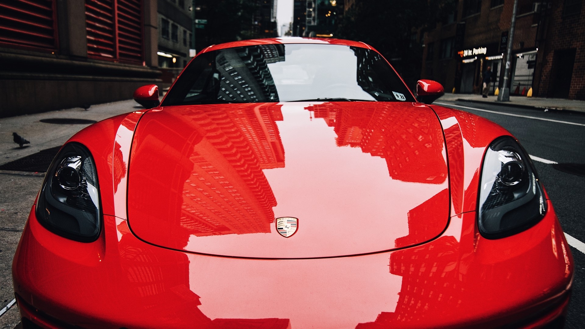 Red Porsche 718 Cayman parked on city street HD Wallpaper