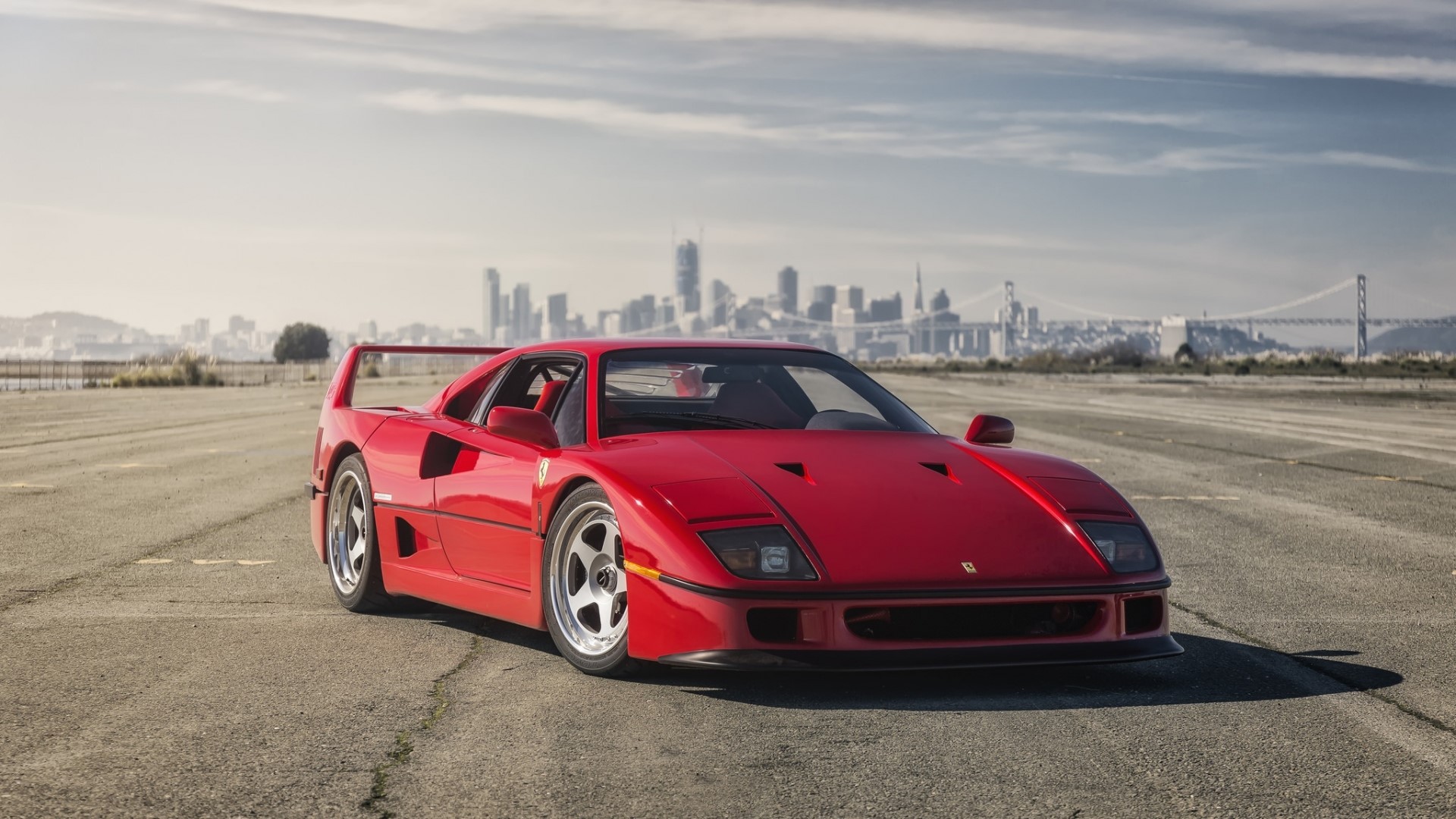 Red Ferrari F40 on asphalt with city skyline HD Wallpaper
