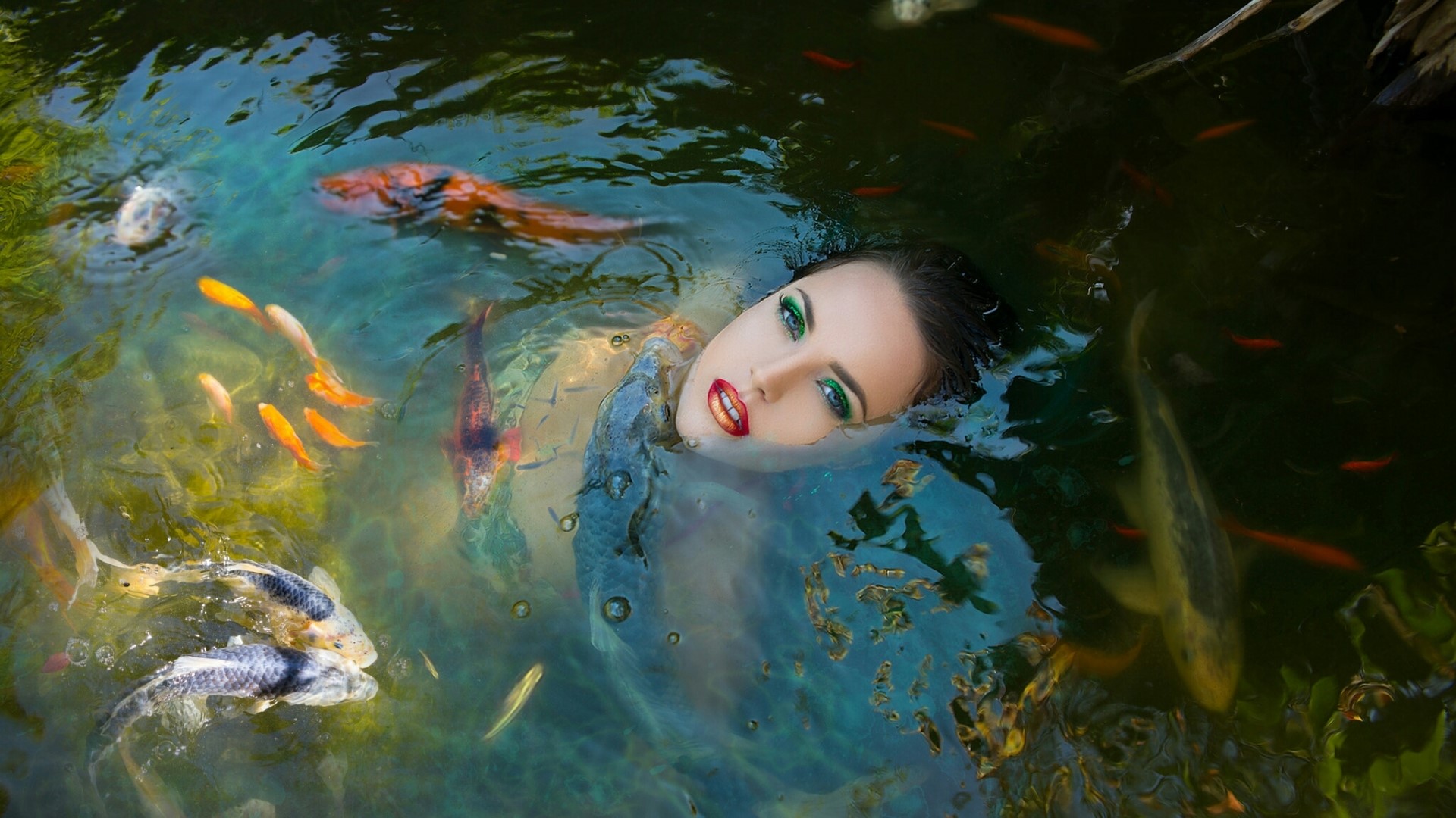 Woman submerged in water with koi fish HD Wallpaper