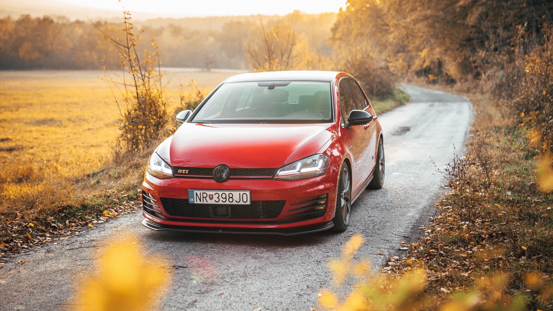 Red Volkswagen Golf GTI on a country road HD Wallpaper