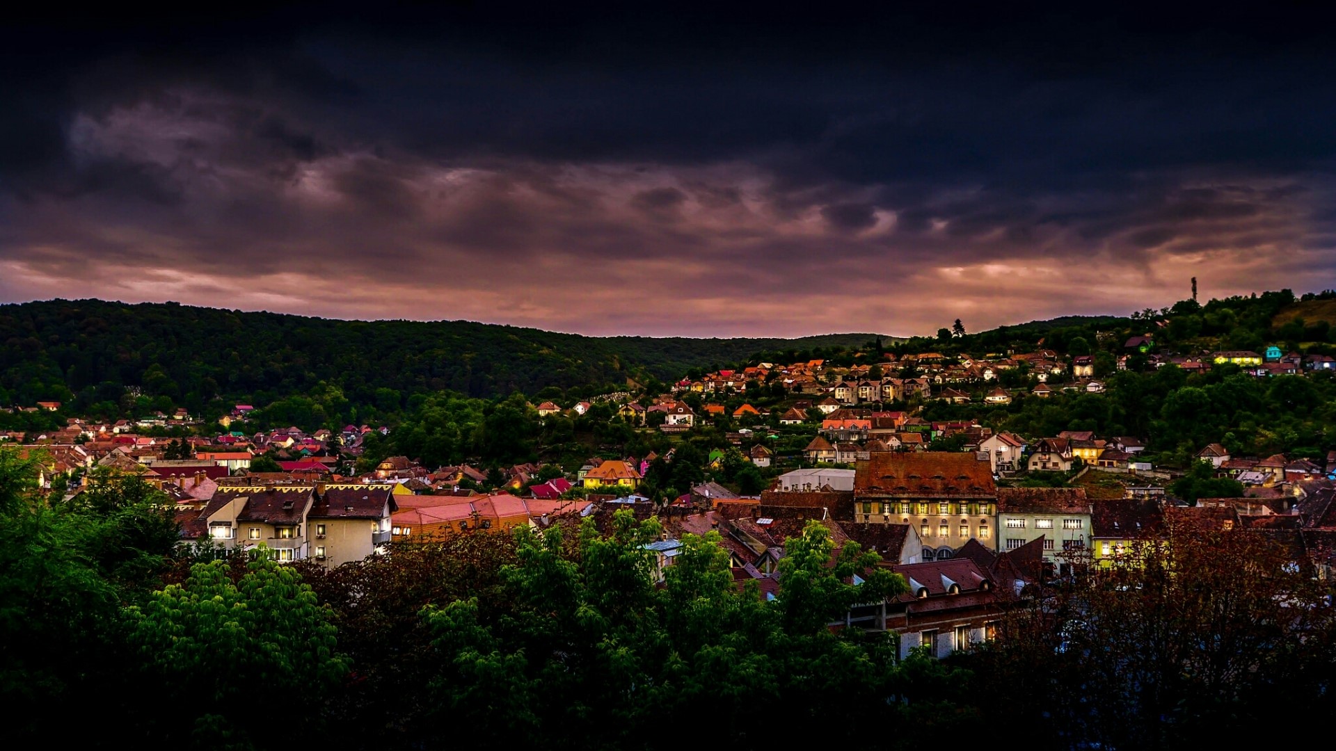 Cityscape at dusk with rolling hills HD Wallpaper