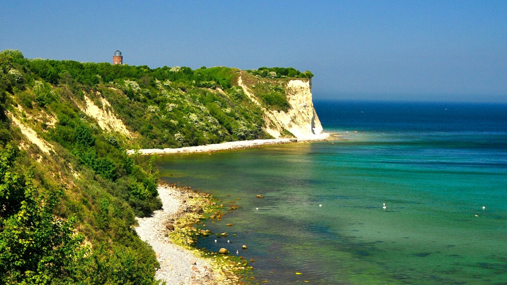 White chalk cliffs and turquoise sea with a lighthouse HD Wallpaper