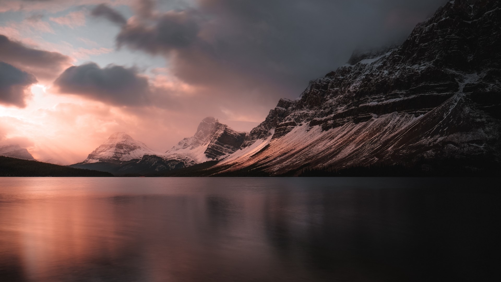 Snowy mountains reflected in a lake at sunset HD Wallpaper