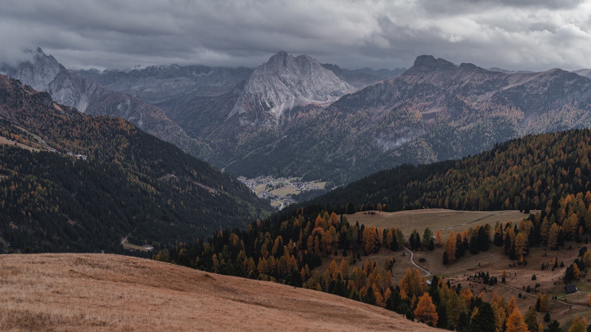 Mountain range with autumn trees and a village HD Wallpaper