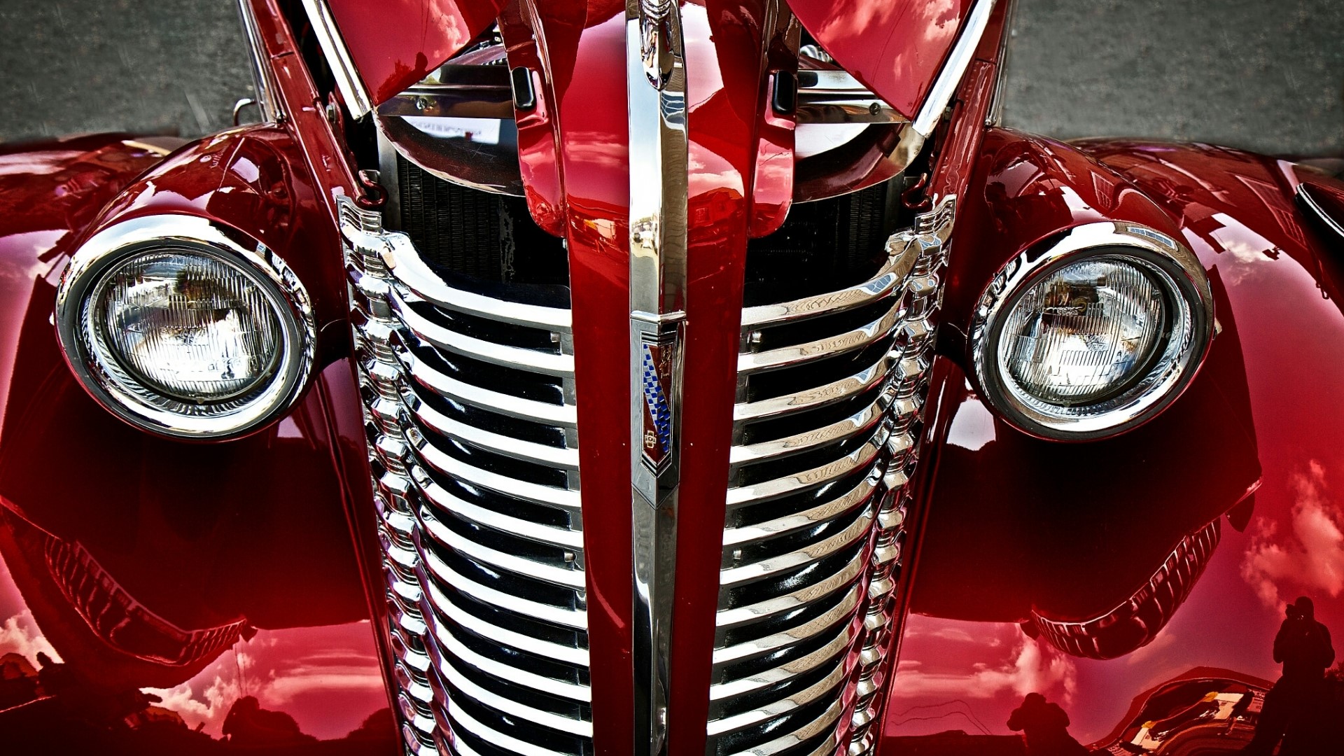 Close-up of a vintage red car grille and headlights HD Wallpaper