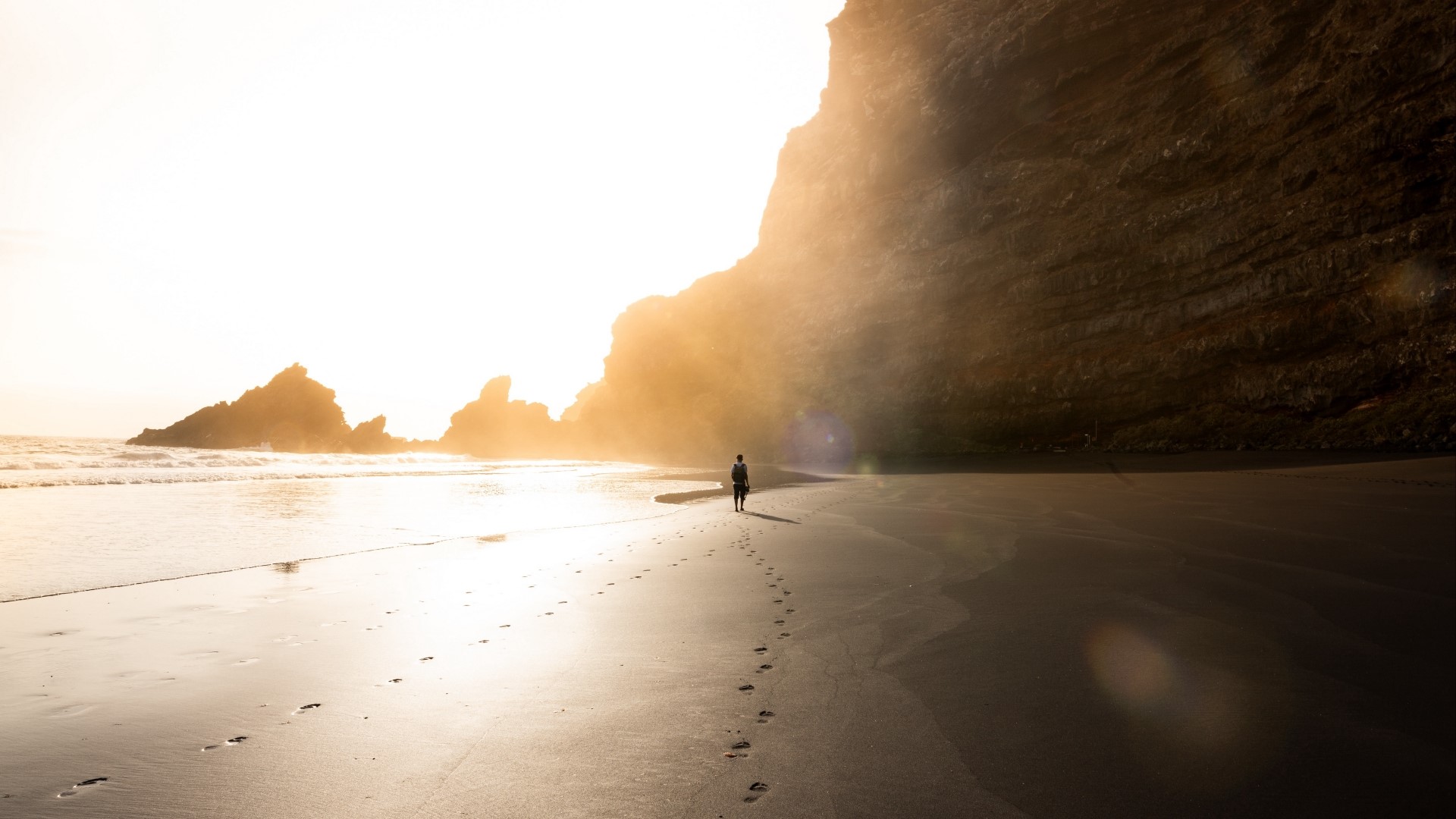 Person walking on a beach at sunset HD Wallpaper