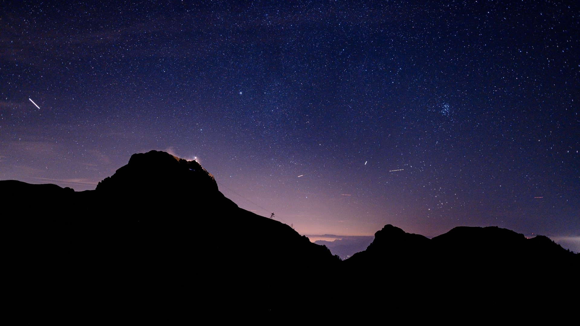 Starry night sky over silhouetted mountains HD Wallpaper