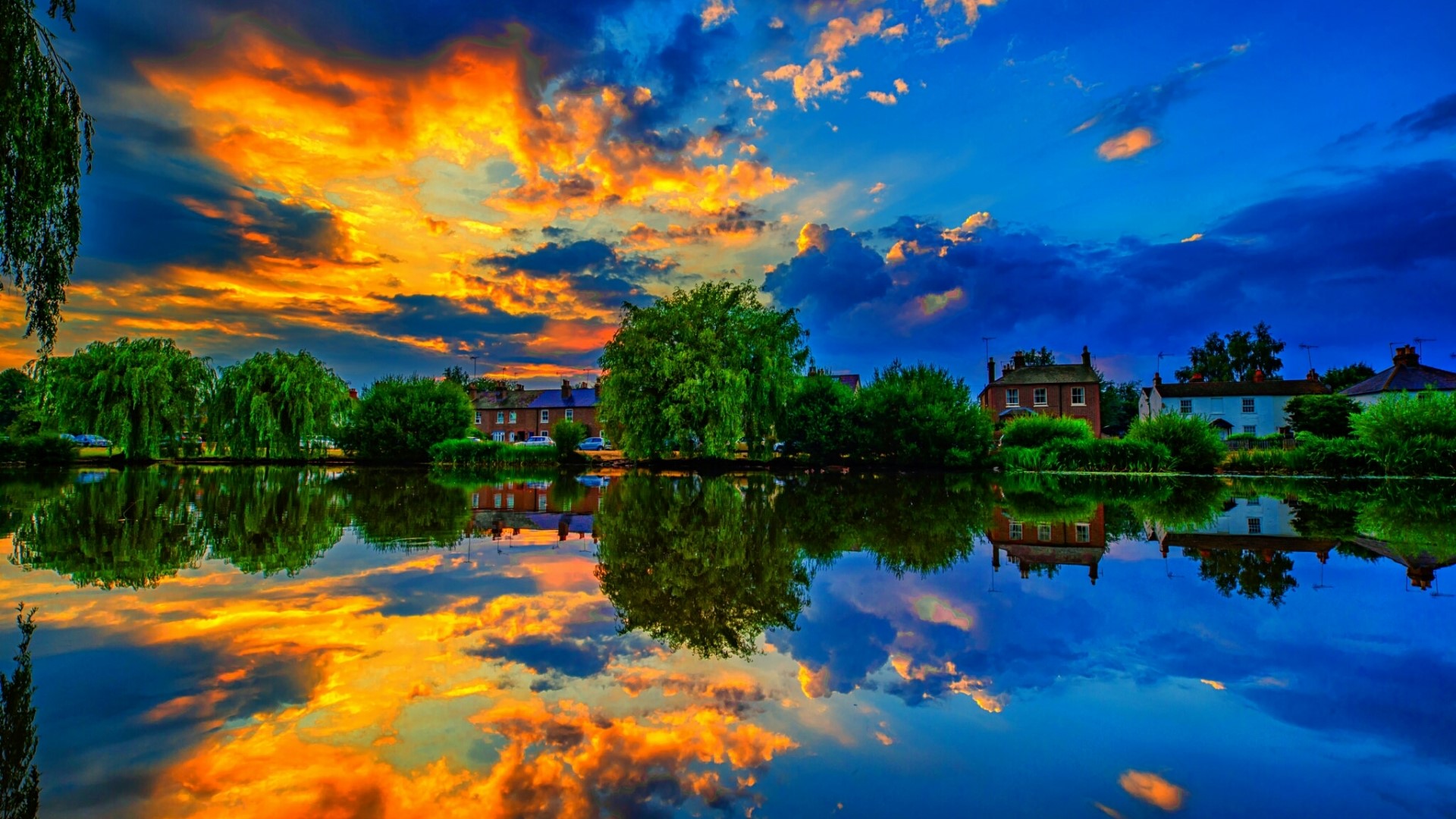 Sunset over a river with houses and trees HD Wallpaper