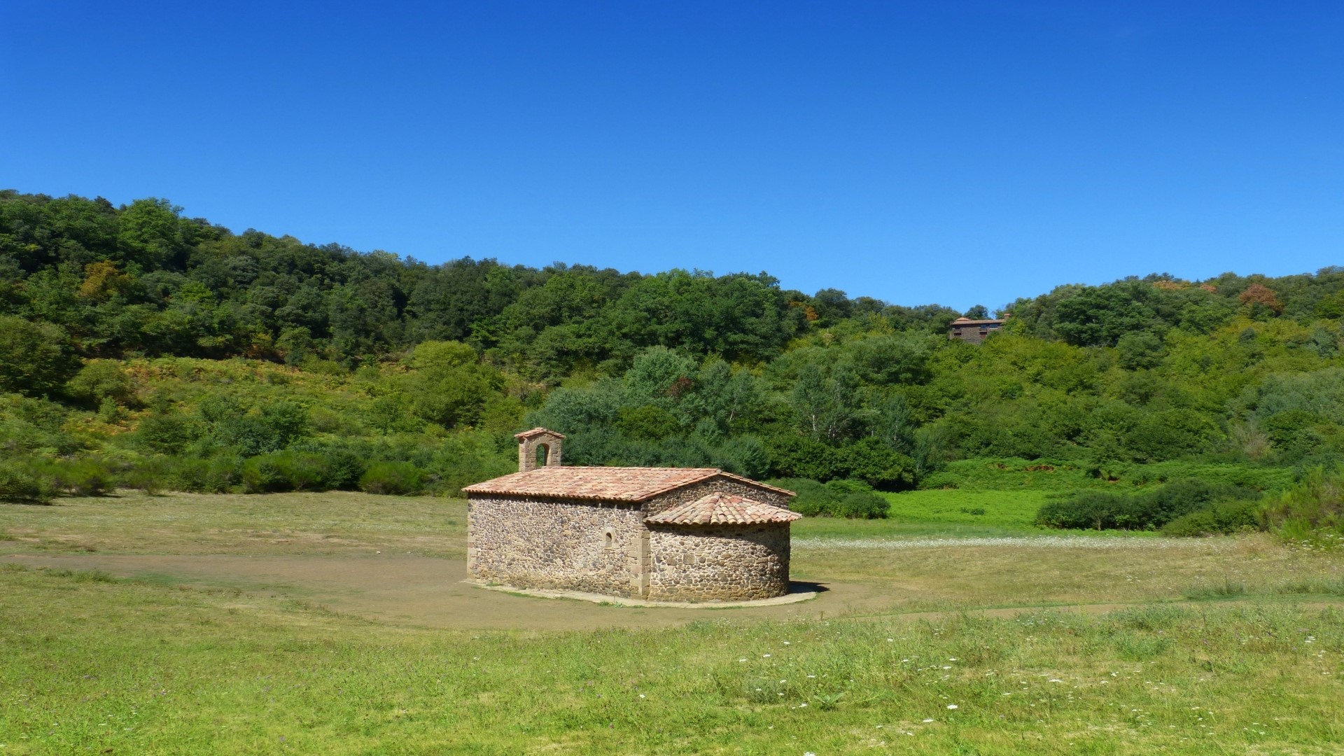 Stone chapel in a green landscape under a blue sky HD Wallpaper