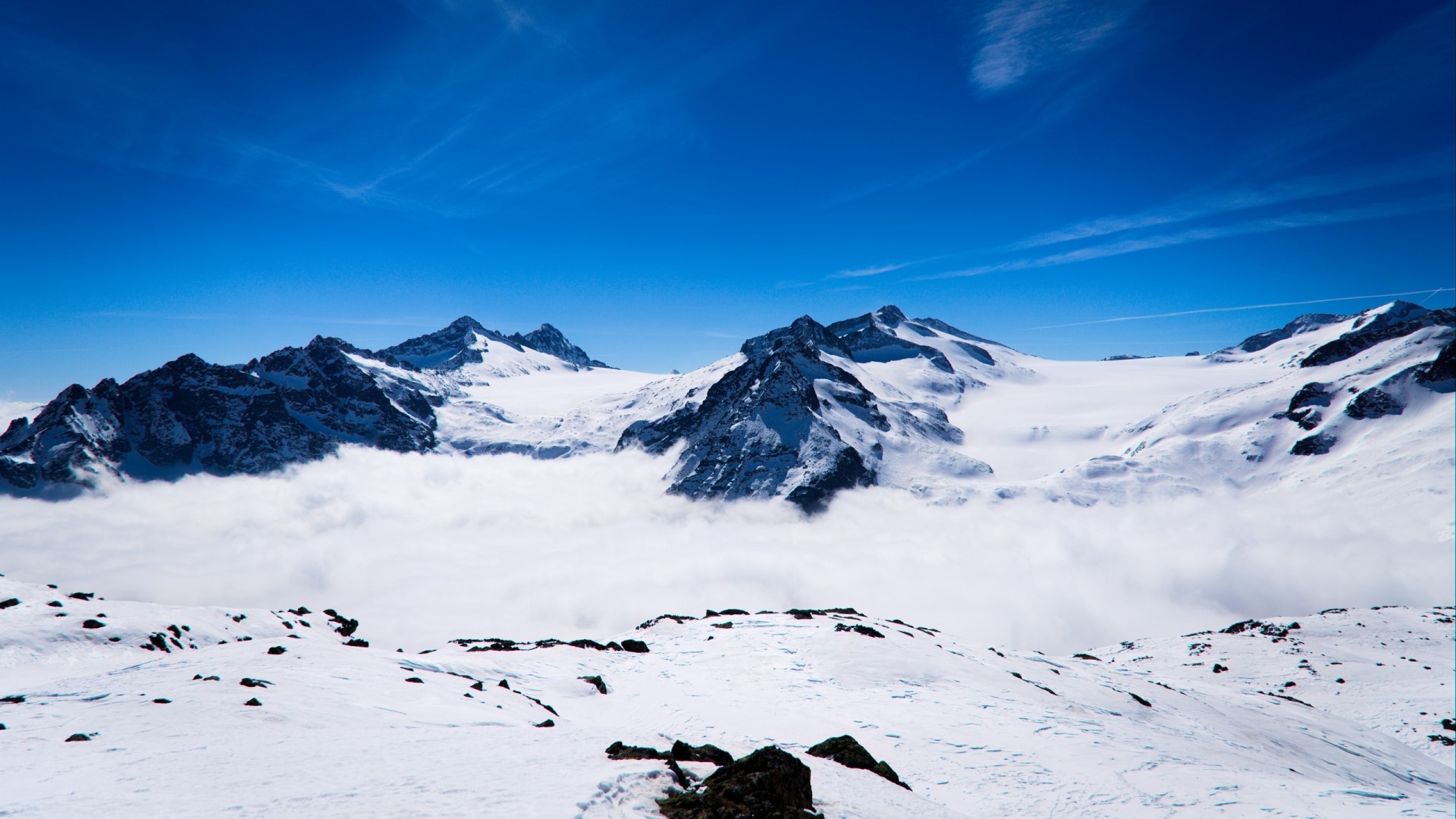 Snowy mountains above clouds under blue sky HD Wallpaper