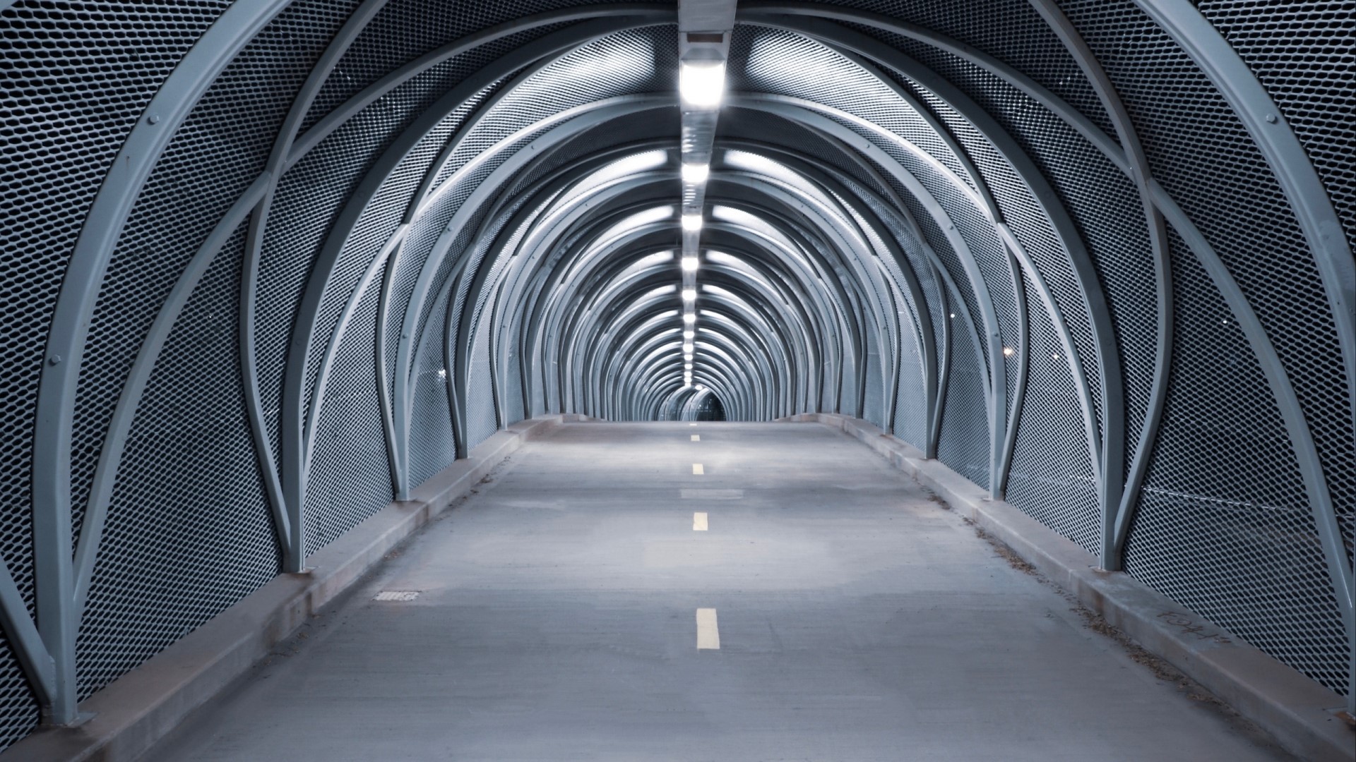 Modern tunnel with arched metal structure HD Wallpaper