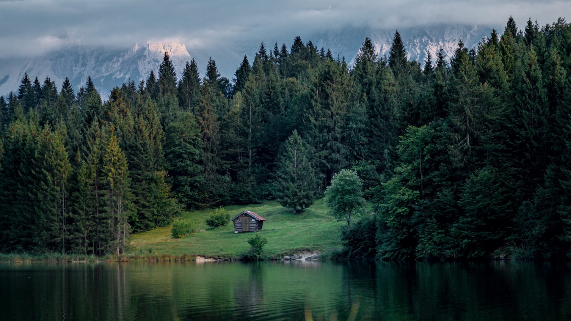 Small cabin by a lake with forest and mountains HD Wallpaper