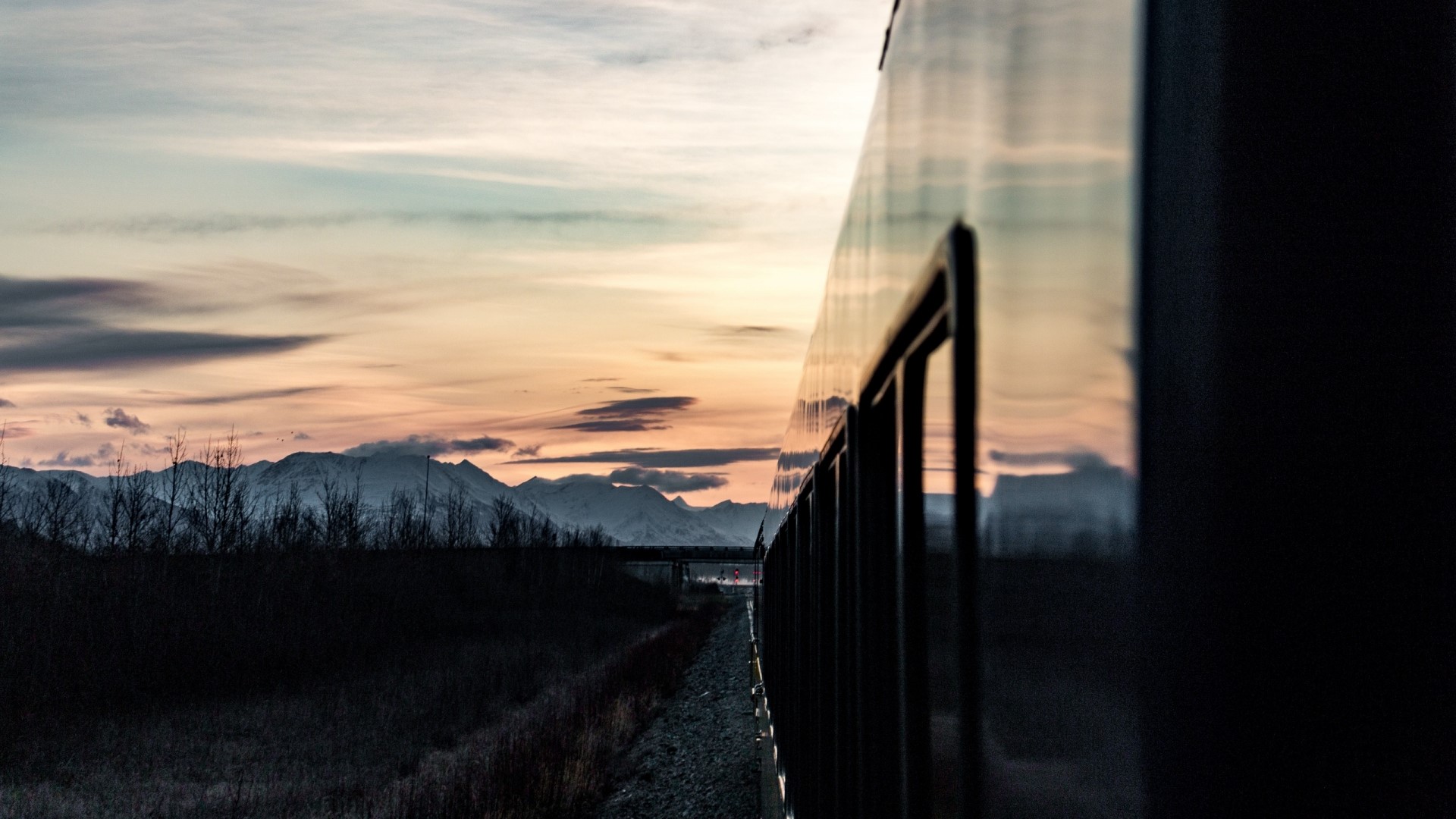Train traveling through mountains at sunset HD Wallpaper
