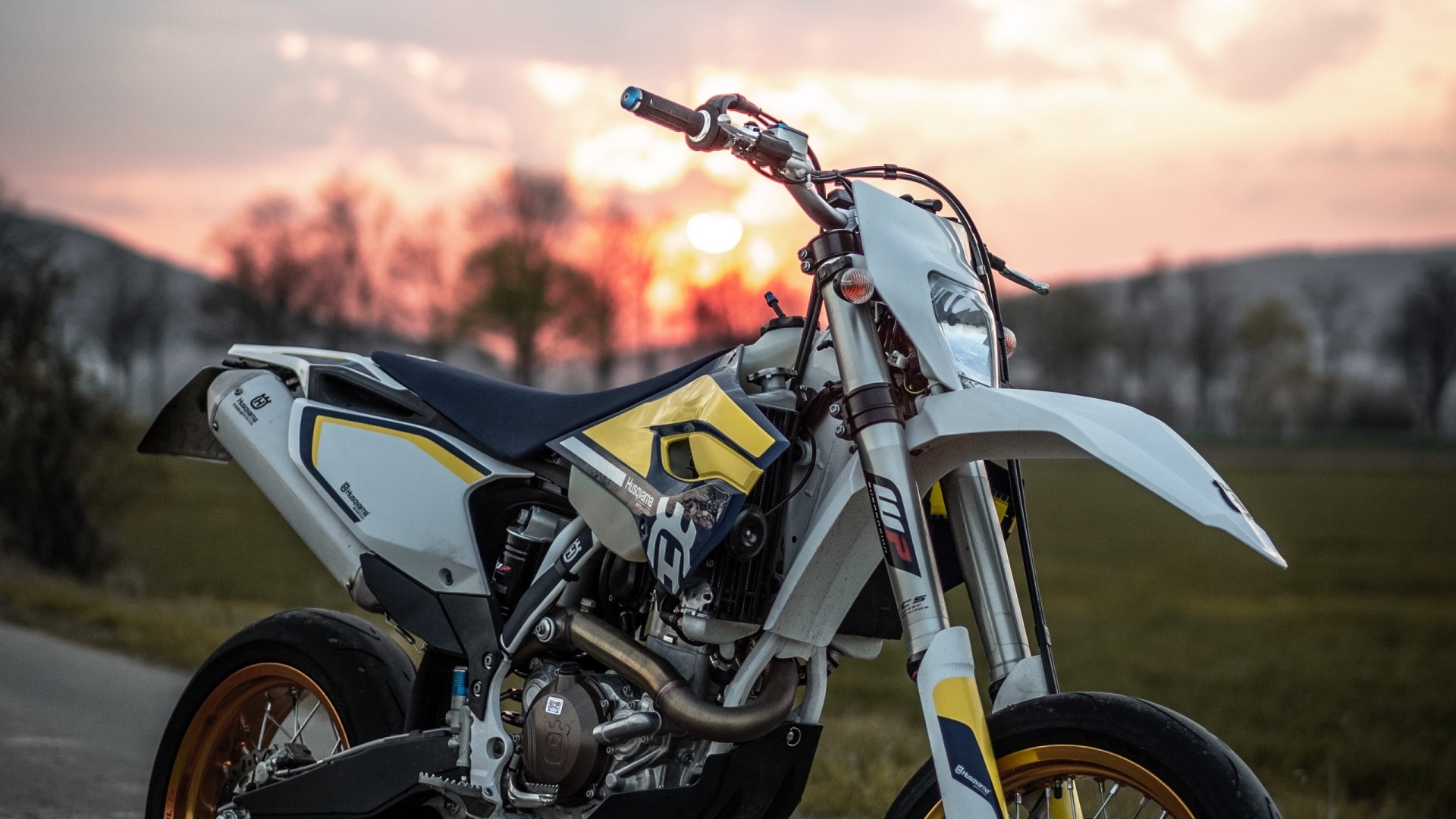 White and yellow Husqvarna dirt bike at sunset HD Wallpaper