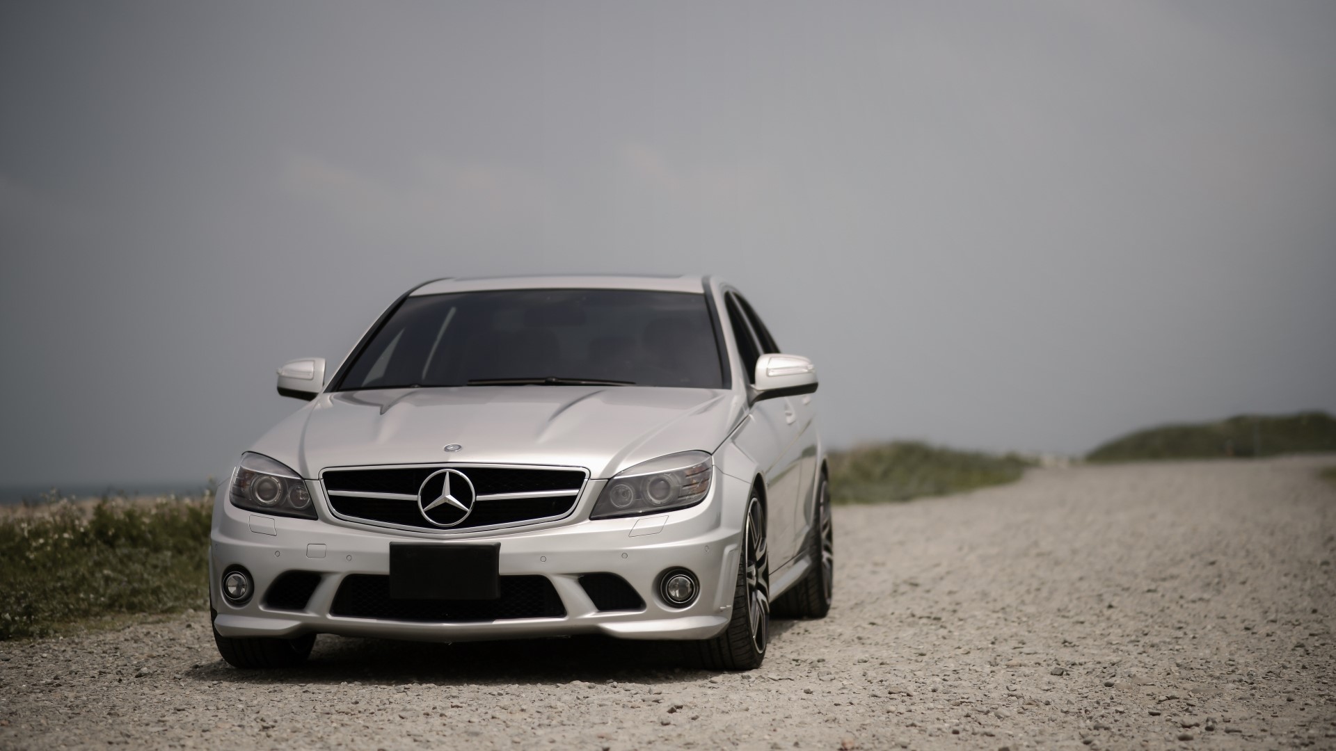 Silver Mercedes-Benz W204 parked on a gravel road HD Wallpaper