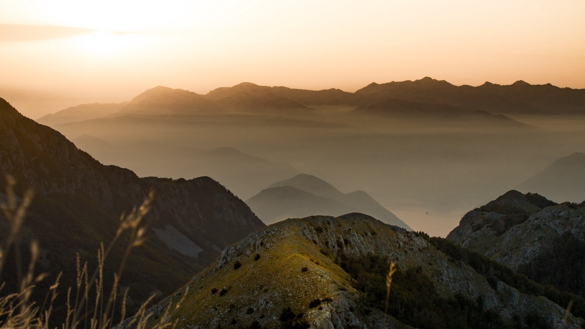 Mountain range at sunset with mist HD Wallpaper