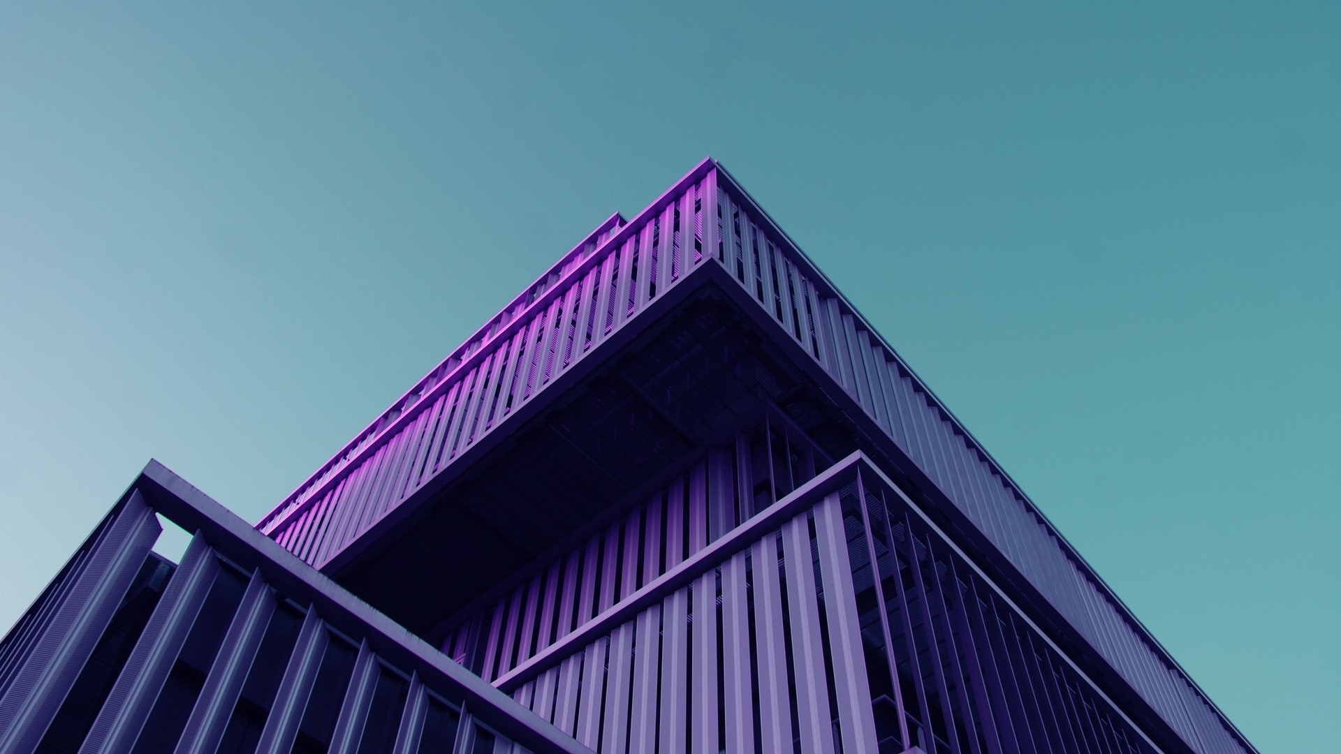 Modern building with purple lighting against a teal sky HD Wallpaper