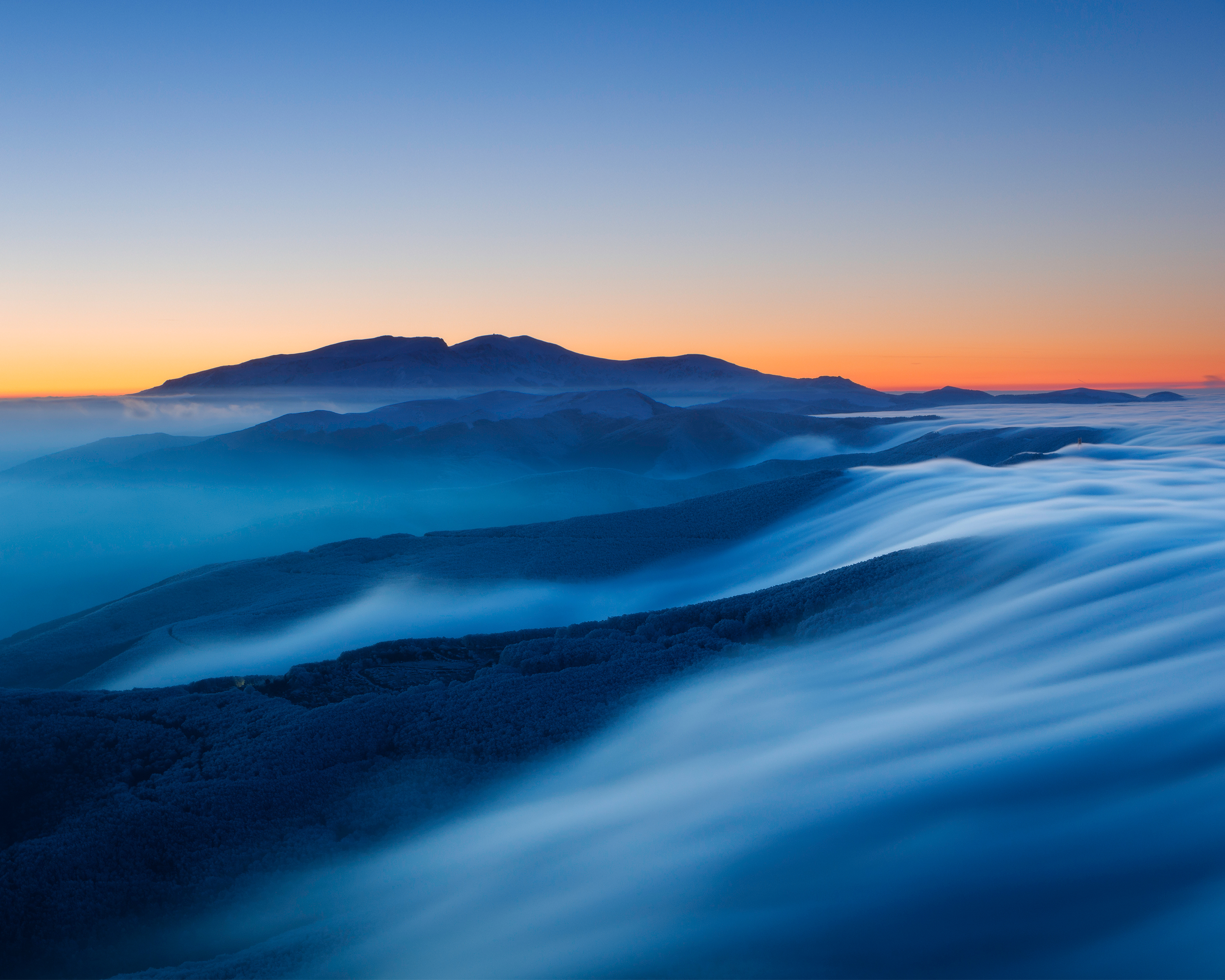 Foggy mountains at sunset with a clear sky HD Wallpaper