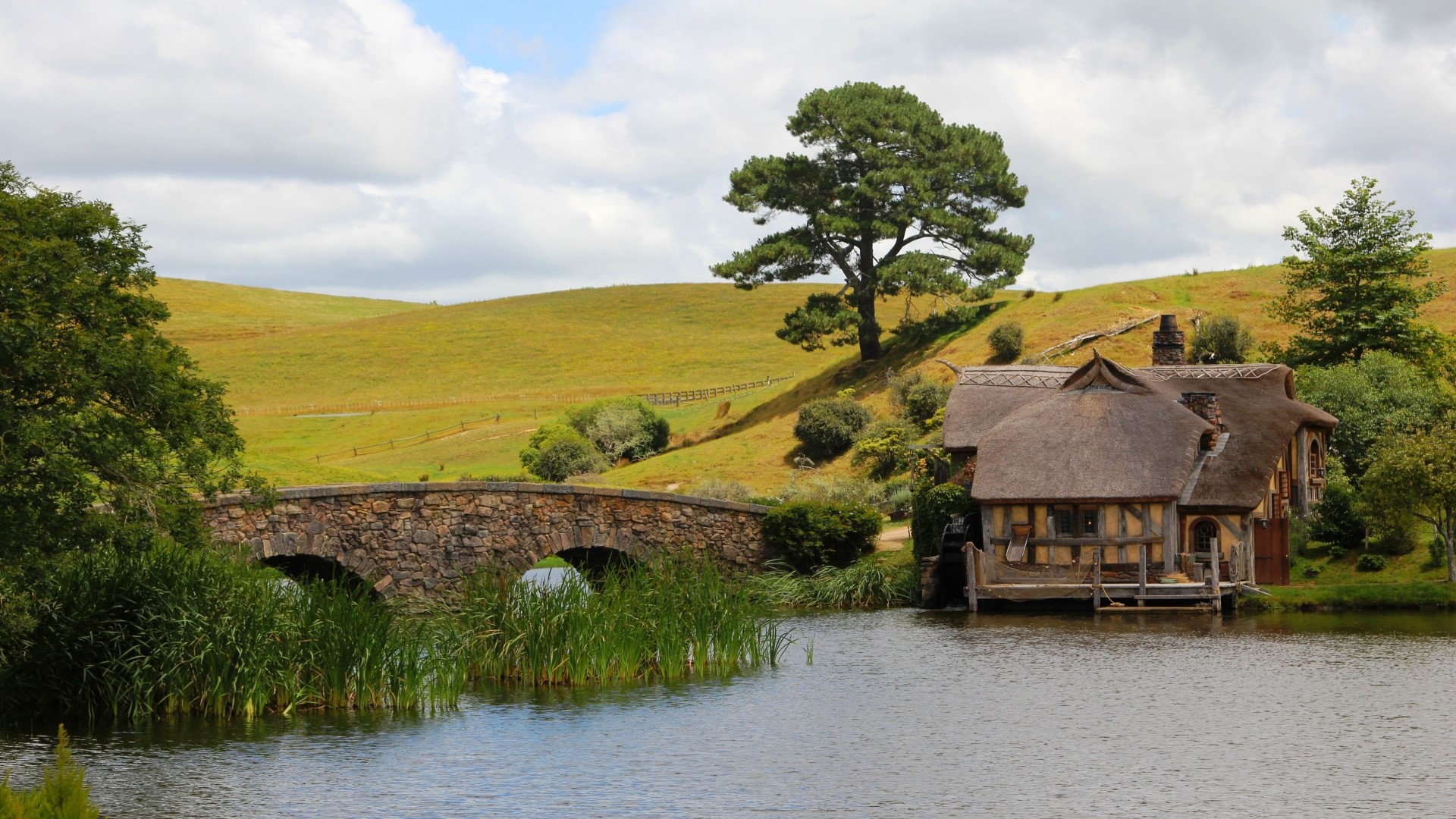 Hobbiton village with stone bridge and lake HD Wallpaper
