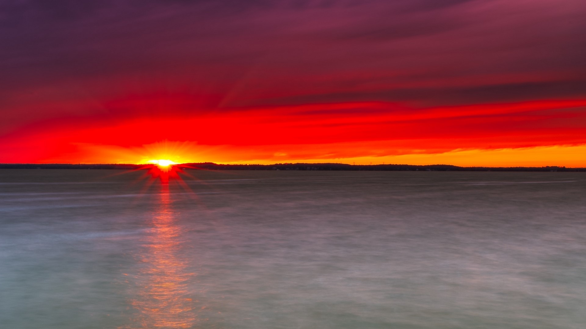 Sunset over a body of water HD Wallpaper