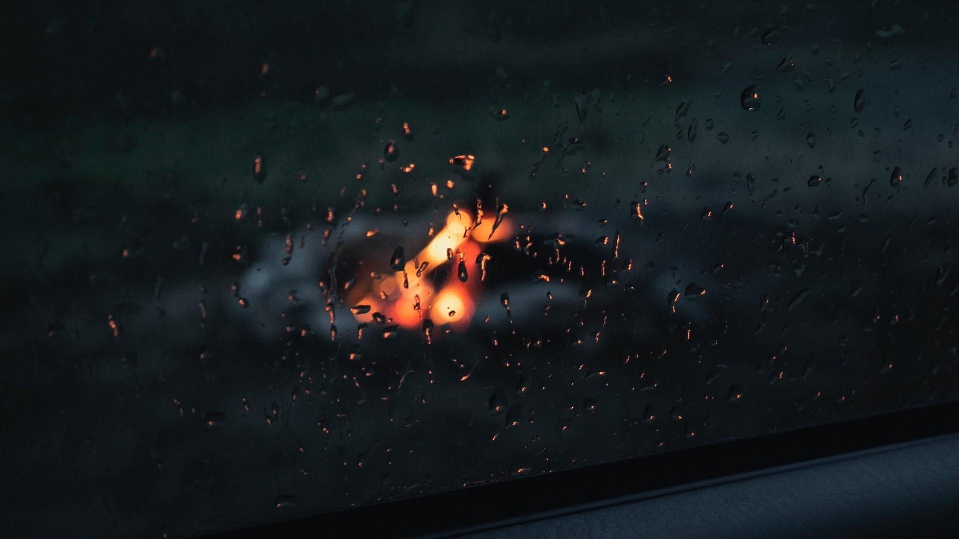 Raindrops on glass with blurred campfire lights HD Wallpaper