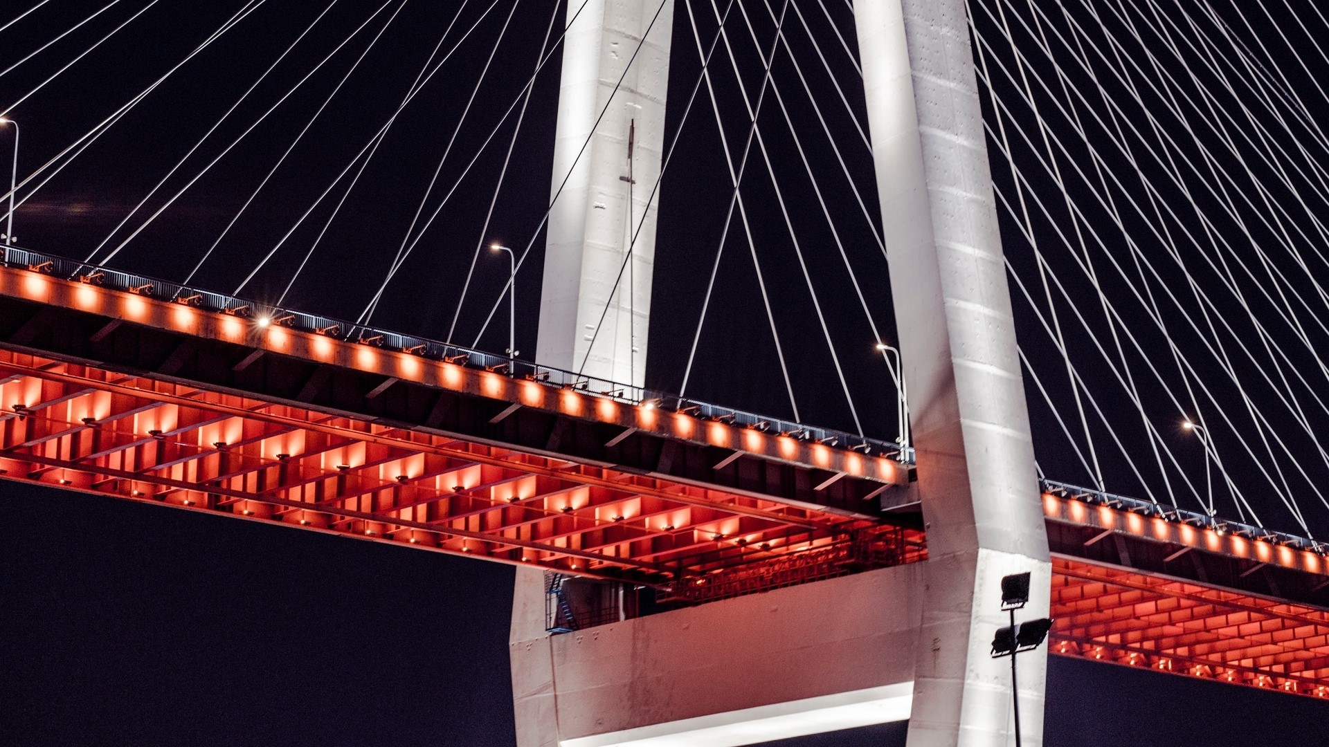 Cable-stayed bridge at night with red lights HD Wallpaper