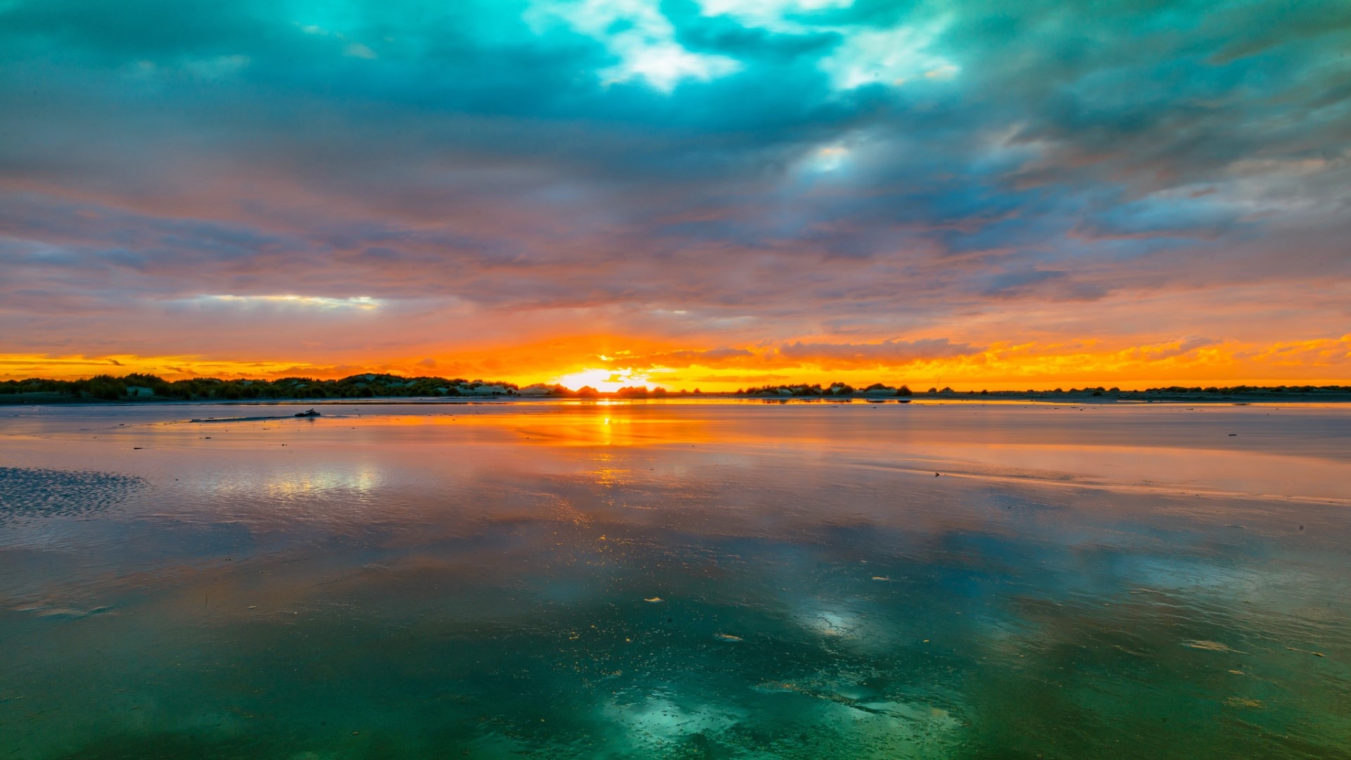 Sunset over a reflective body of water with colorful clouds HD Wallpaper