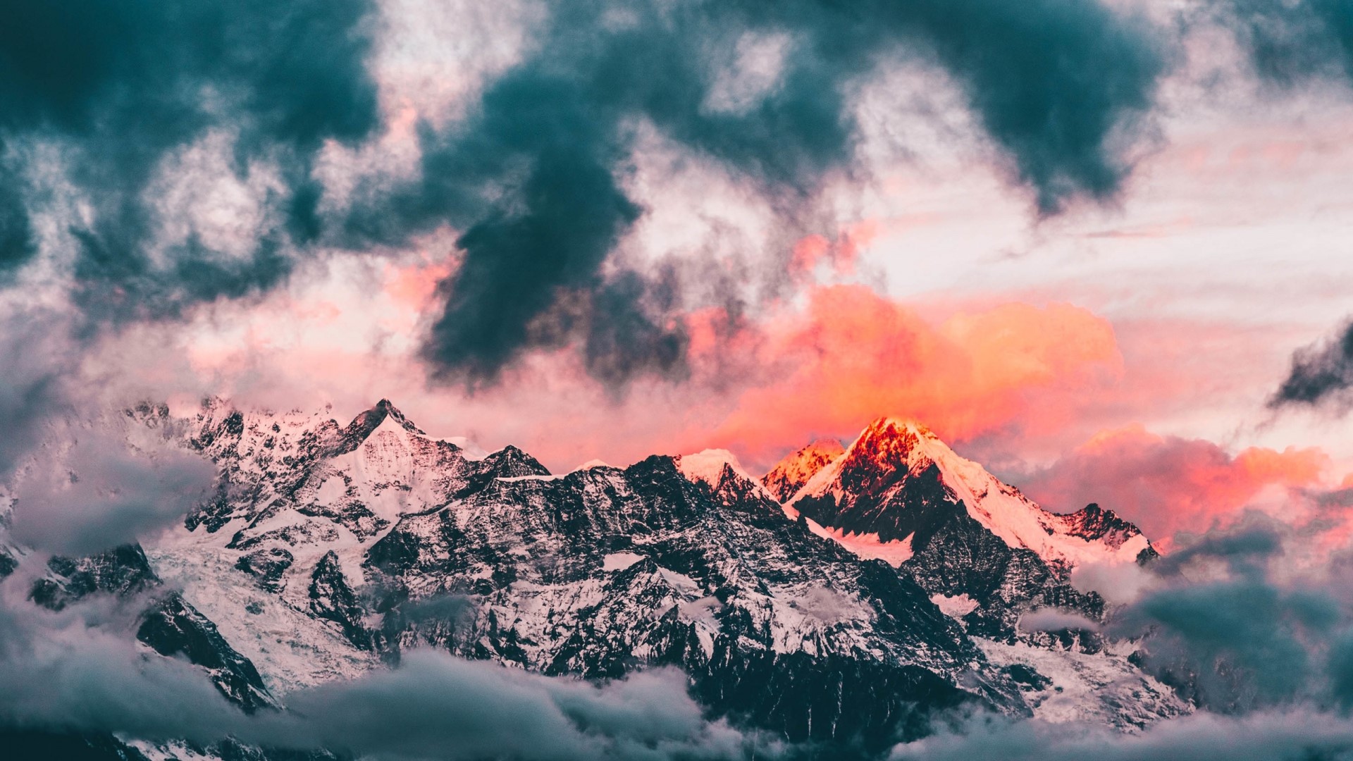 Sunset over snow-capped mountains with dramatic clouds HD Wallpaper