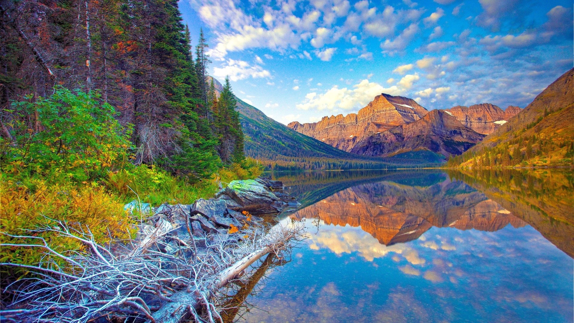 Mountains reflected in a lake under a cloudy sky HD Wallpaper